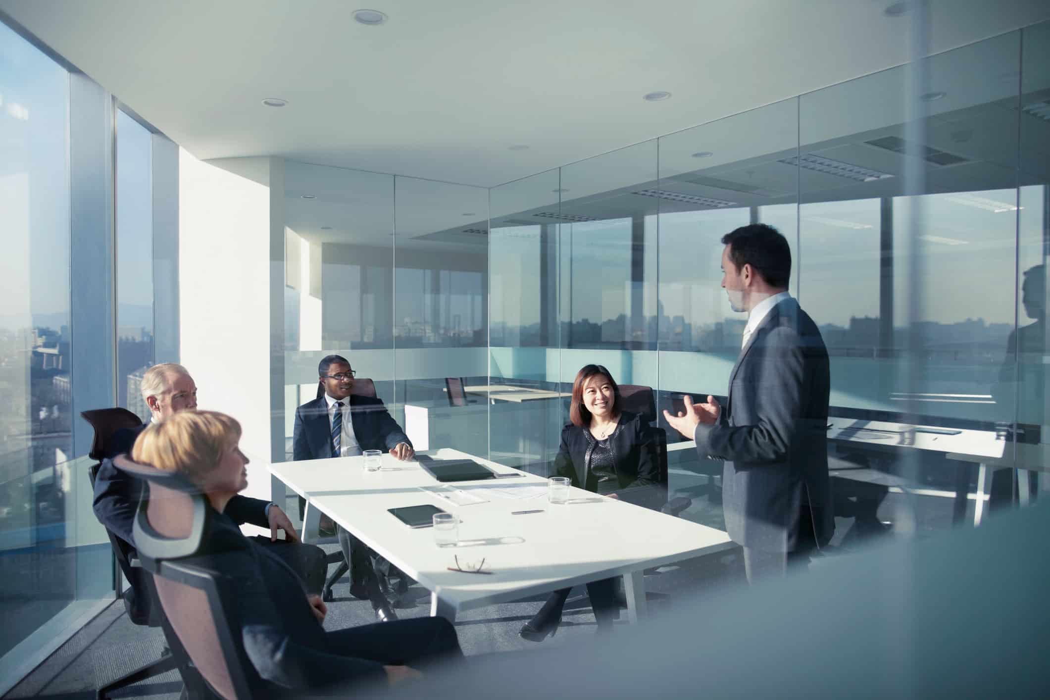 Five people discuss Securities Litigation in a modern glass-walled conference room.