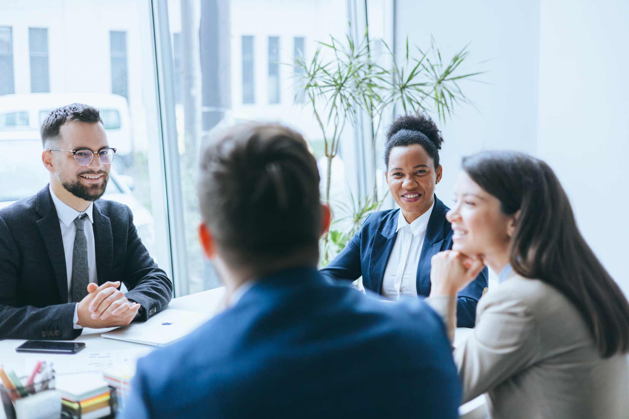 Four people discuss legal automation and strategic planning in a bright, modern office.