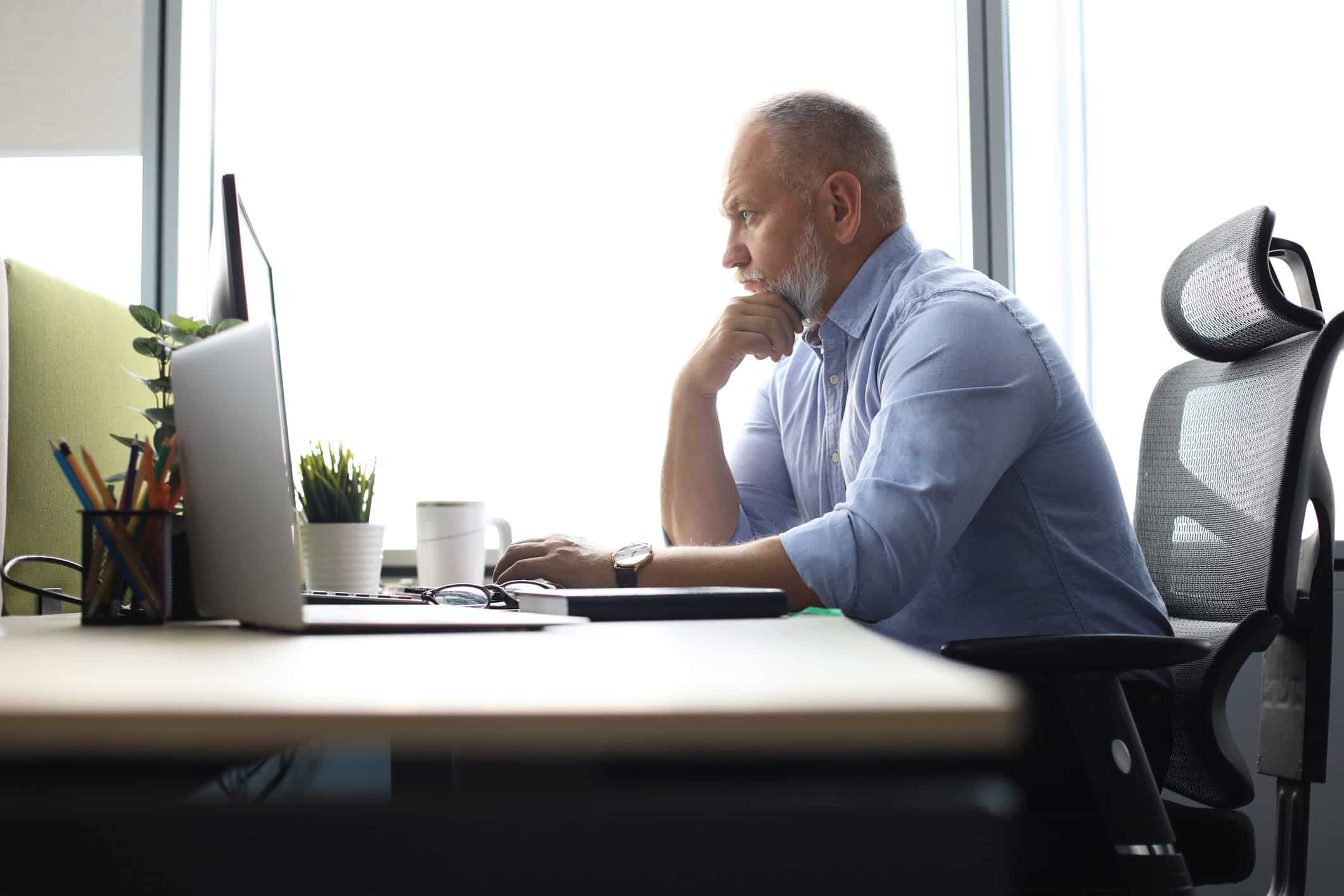 Man at desk focused on computer, working on securities litigation consulting services.