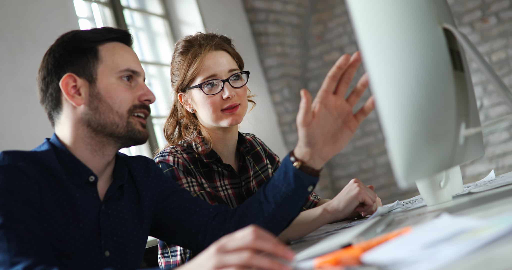 Two people at a computer, discussing Reviewer Training & Protocol Alignment on the screen.