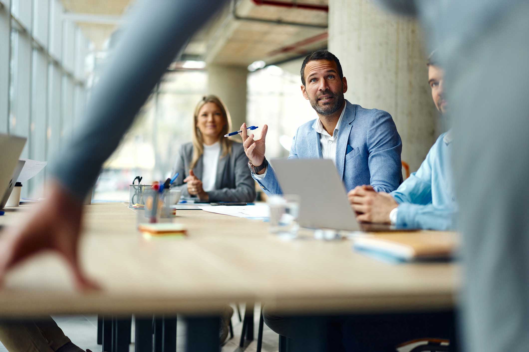 Law Firm Client Relationship Management discussion among businesspeople at a conference table.