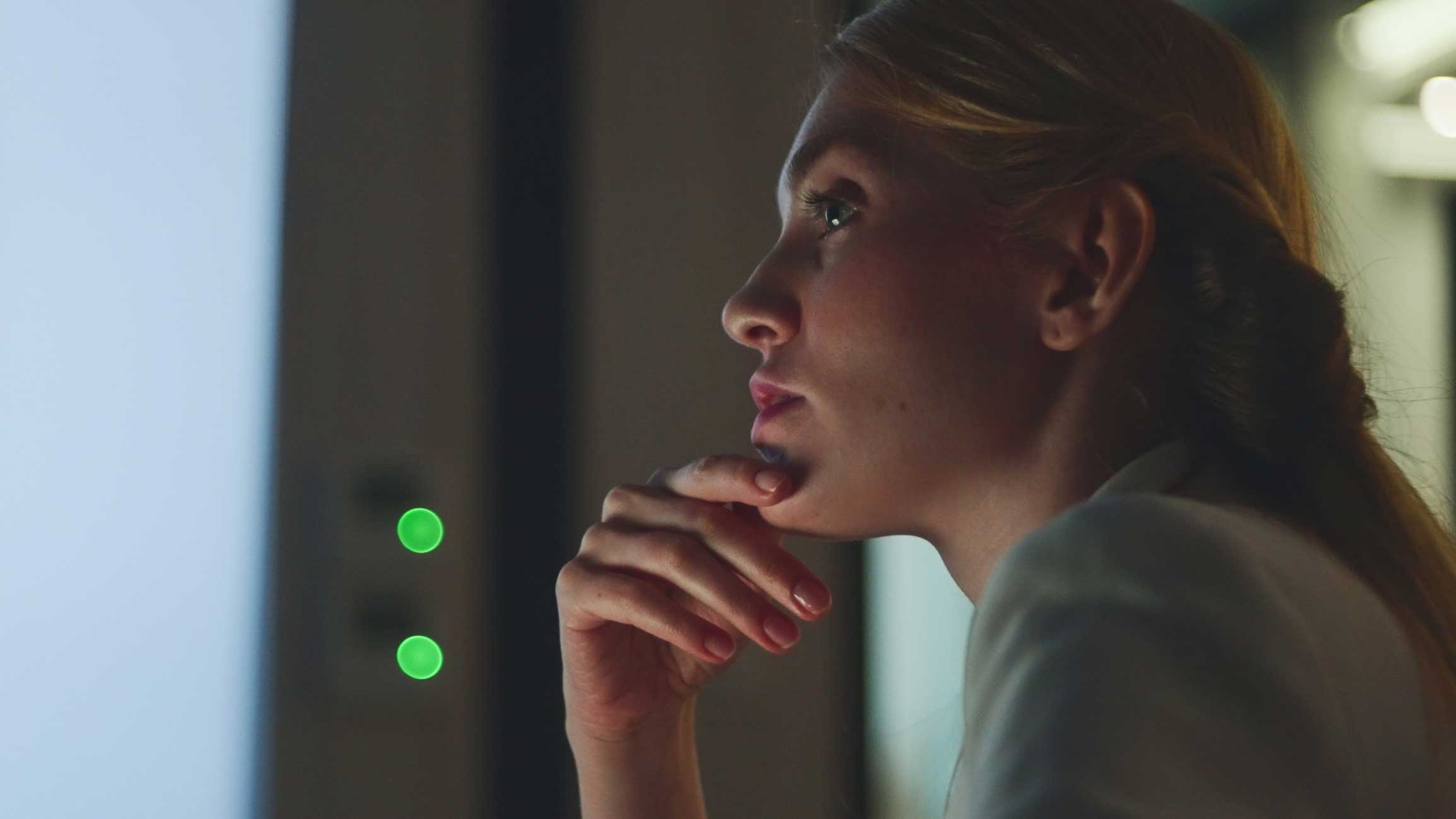 Woman in profile, hand on chin, reflecting on an IT disaster recovery consulting firm.