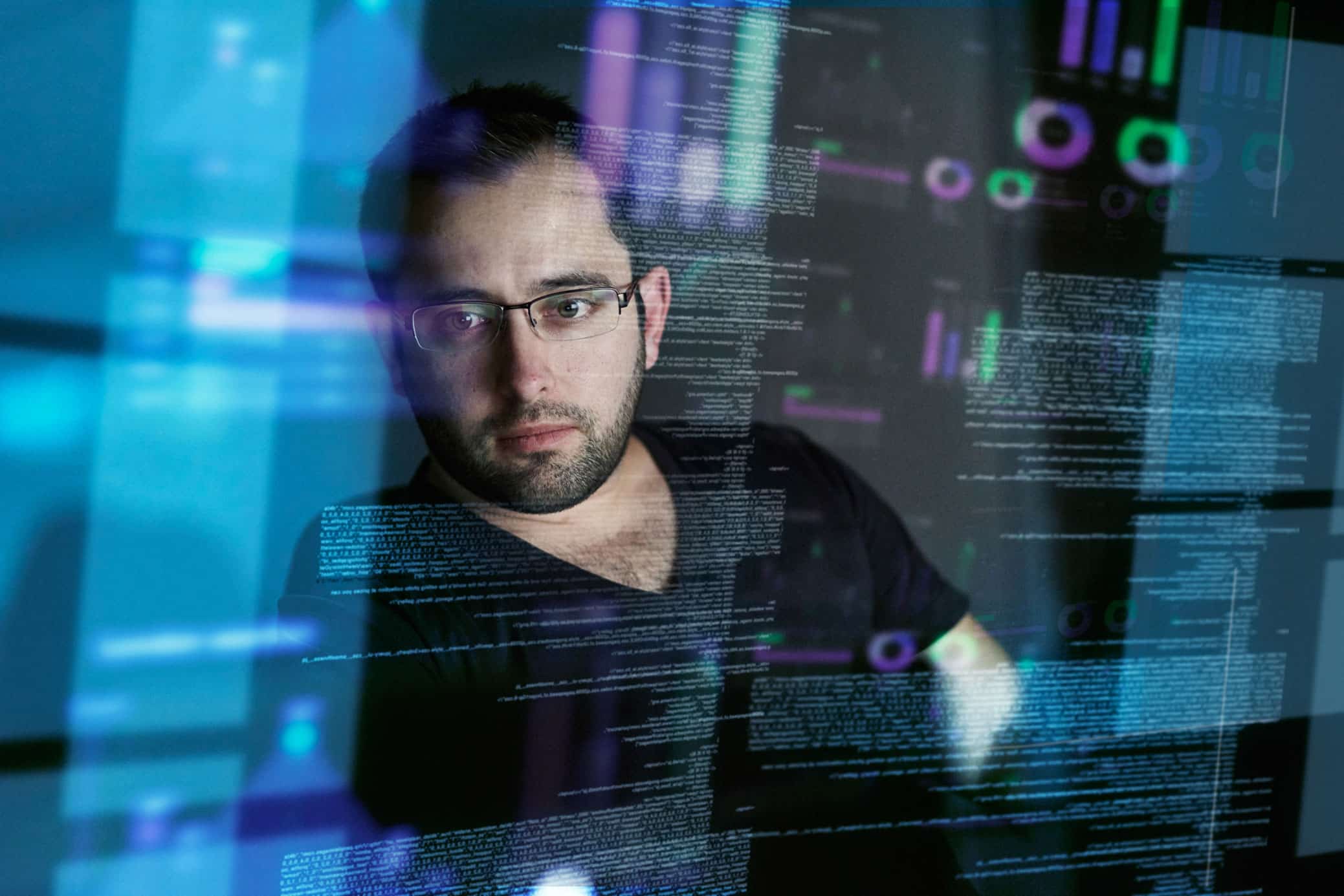 Man with glasses analyzing code at a Modern Data Architecture Consulting Firm.
