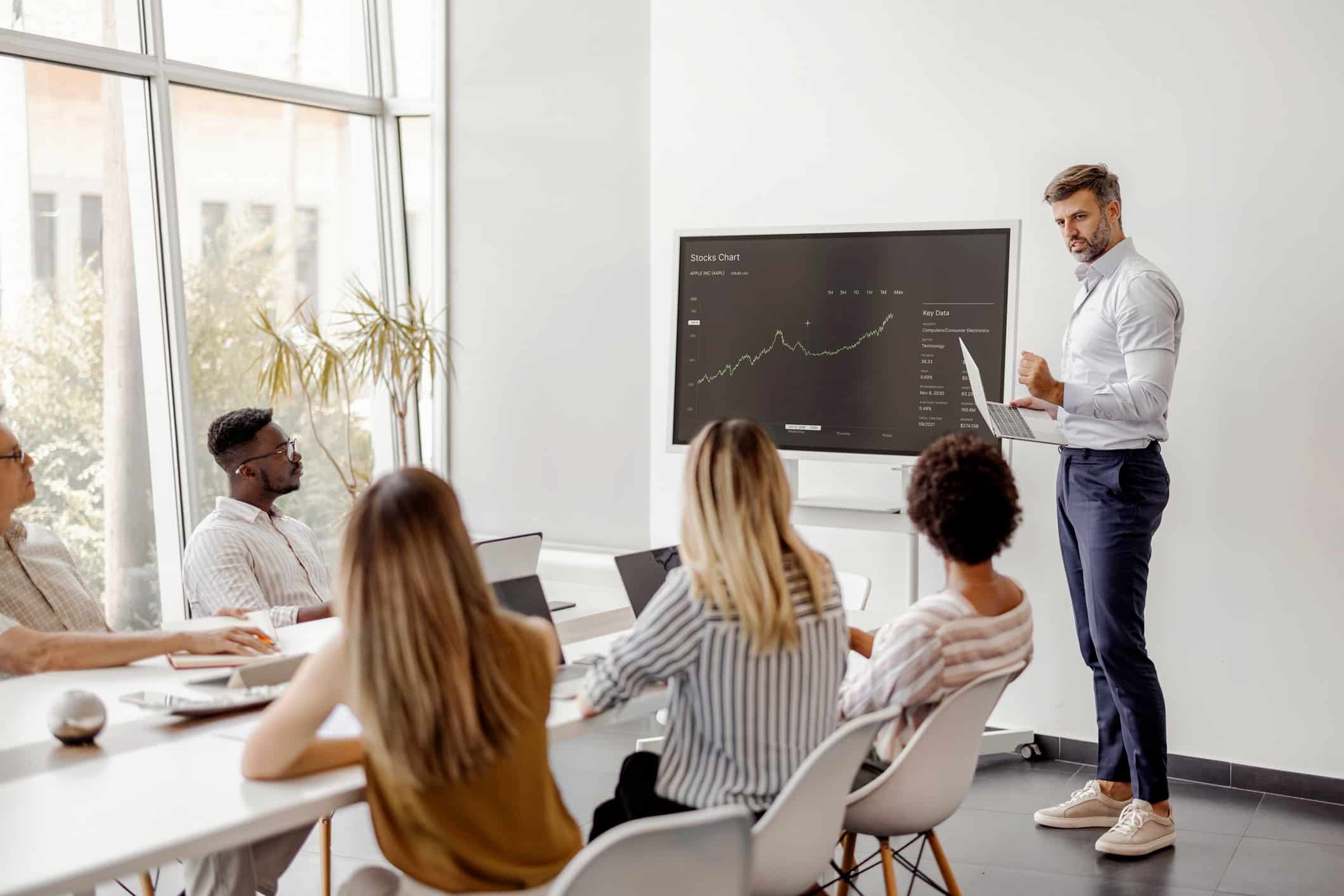 Man presenting Data Governance insights to colleagues in modern office meeting room.