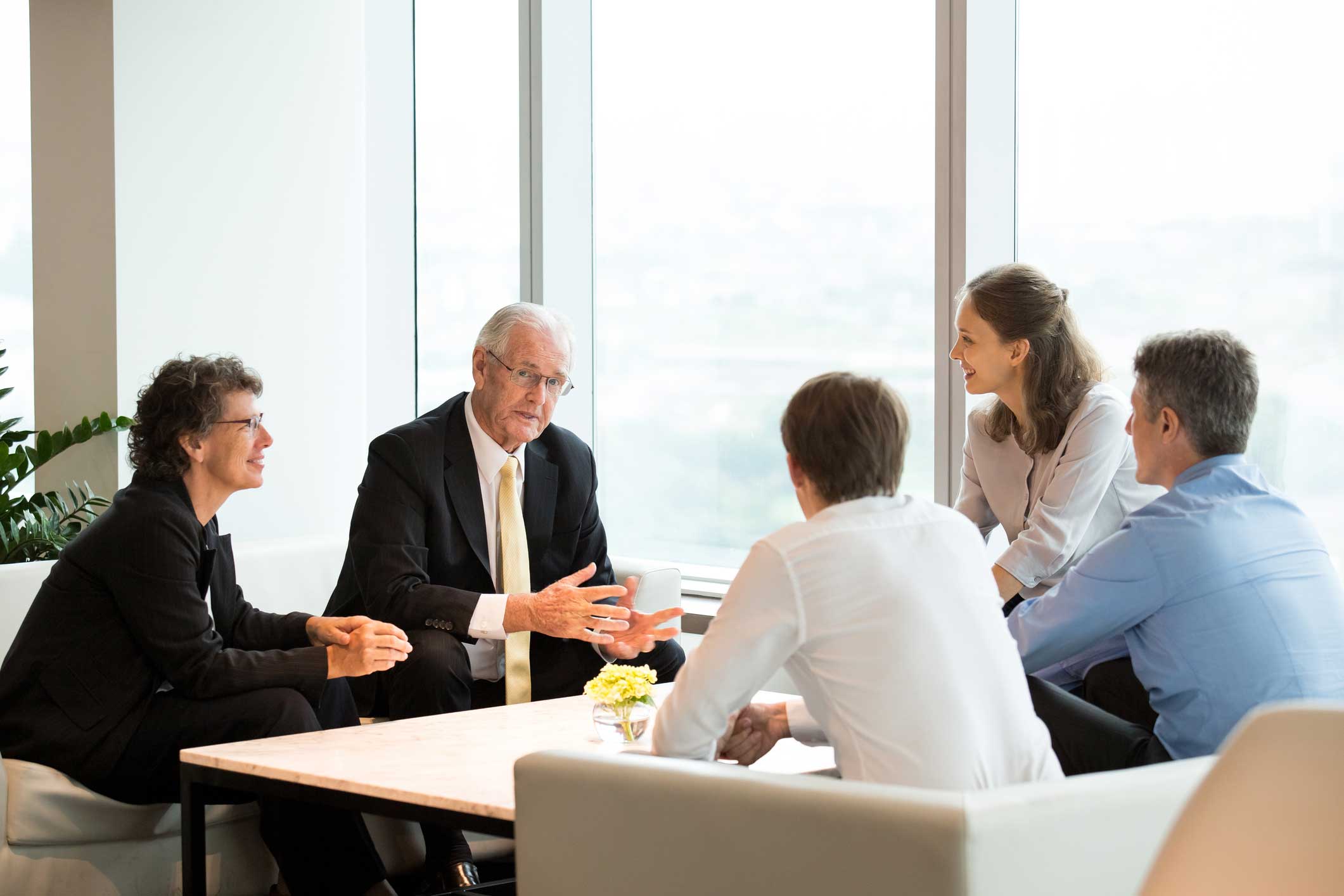 Five people discuss MDM Strategic Planning around a table in a bright, modern office.