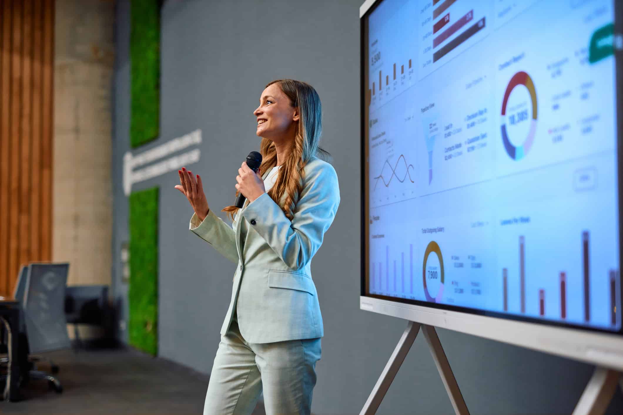 Woman in suit presents charts on law firm growth technology during a business meeting.