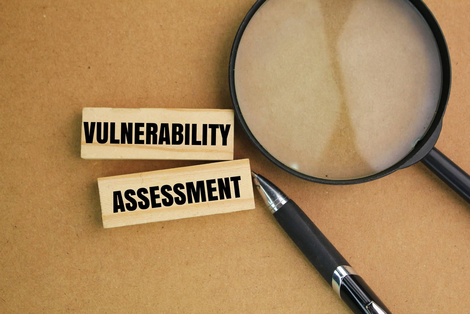 Wood blocks with VULNERABILITY ASSESSMENT, pen, & magnifier for Witness Preparation Consulting firm.