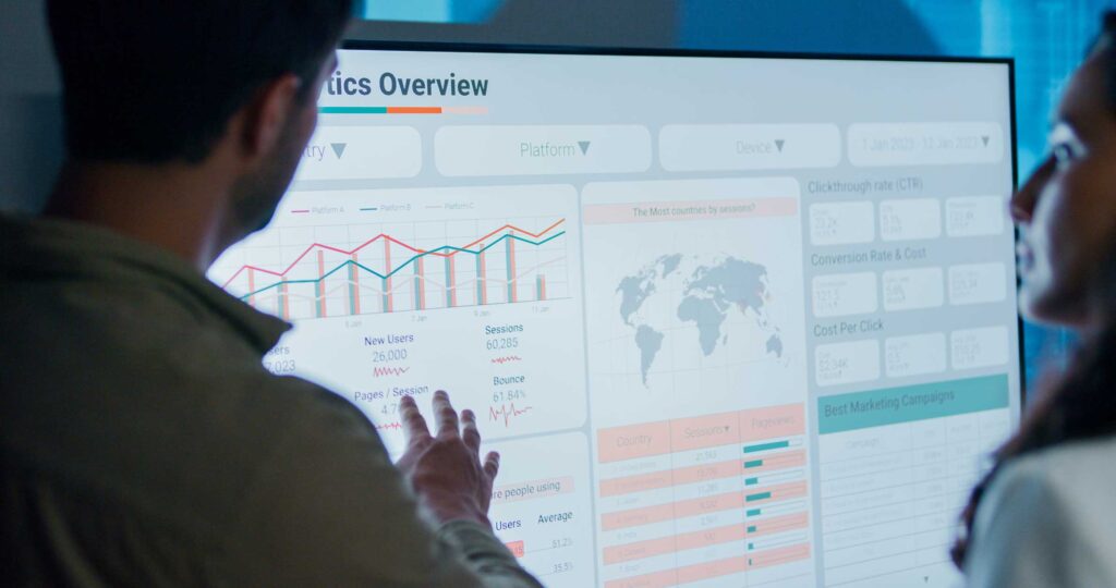 Two people reviewing eDiscovery data analysis charts on a large consulting dashboard screen.