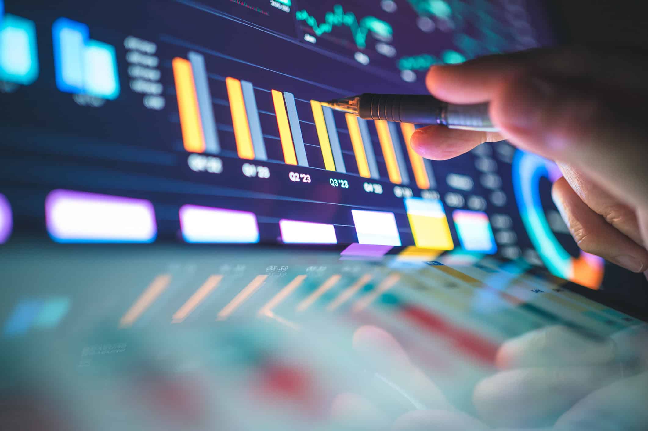 Hand pointing at digital bar graphs on a touchscreen for Law Firm Operations Consulting analysis.