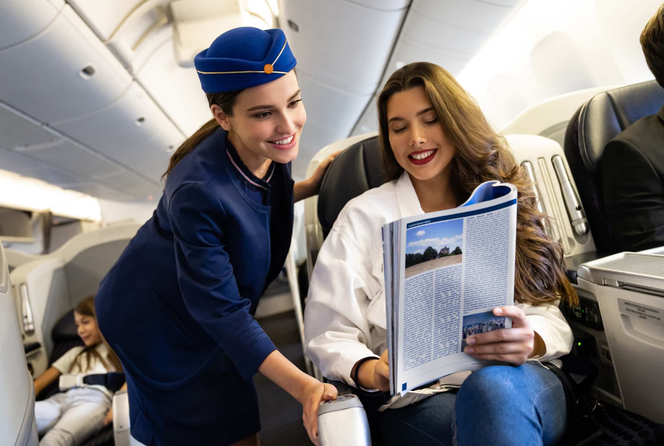 Flight attendant smiling at a passenger, showcasing Airline Agile Organization Design in first class
