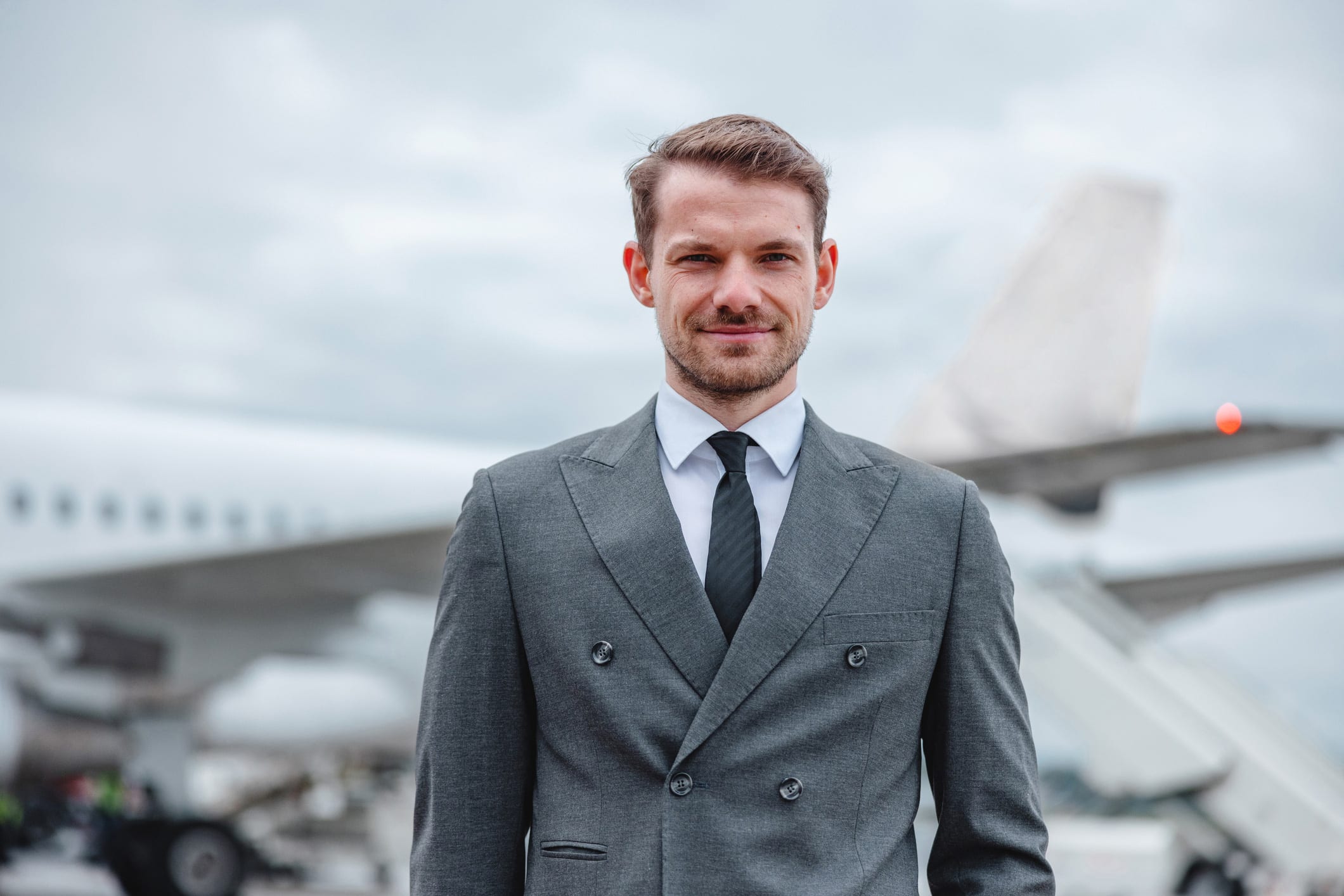 Aviation executive stands in front of an airplane, reflecting search consulting expertise.