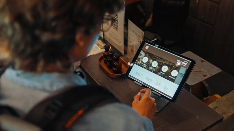 Person using a tablet at a counter, exploring hospitality digital transformation consulting.