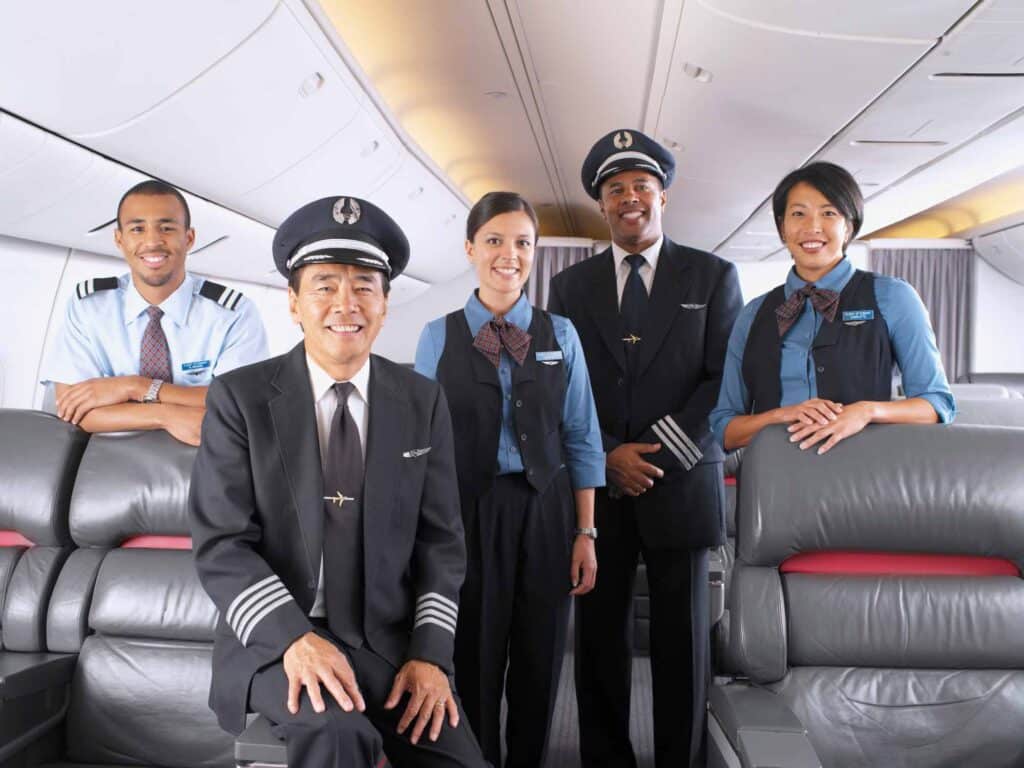 Five airline crew members pose and smile, showcasing aviation organization human capital consulting.