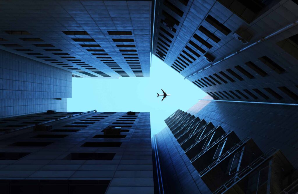 Airplane soaring above city skyscrapers, a view inspired by expert aviation consultants.
