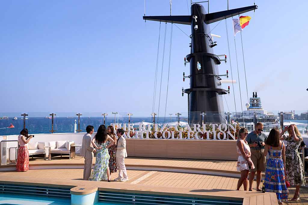 People socializing on a cruise ship deck, guided by expert hospitality consultants, near the pool.