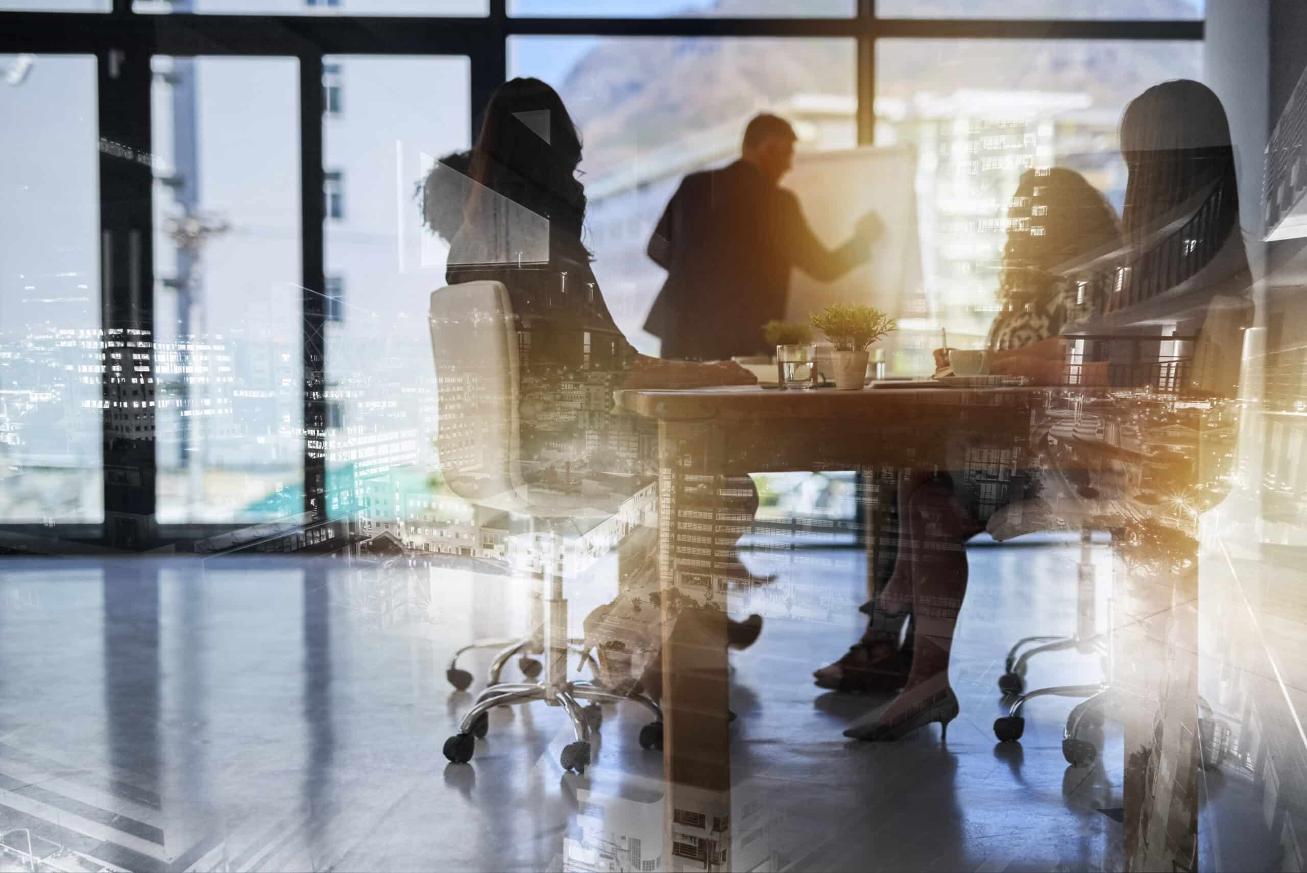 Silhouetted people in a modern office meeting, discussing artificial intelligence consulting.