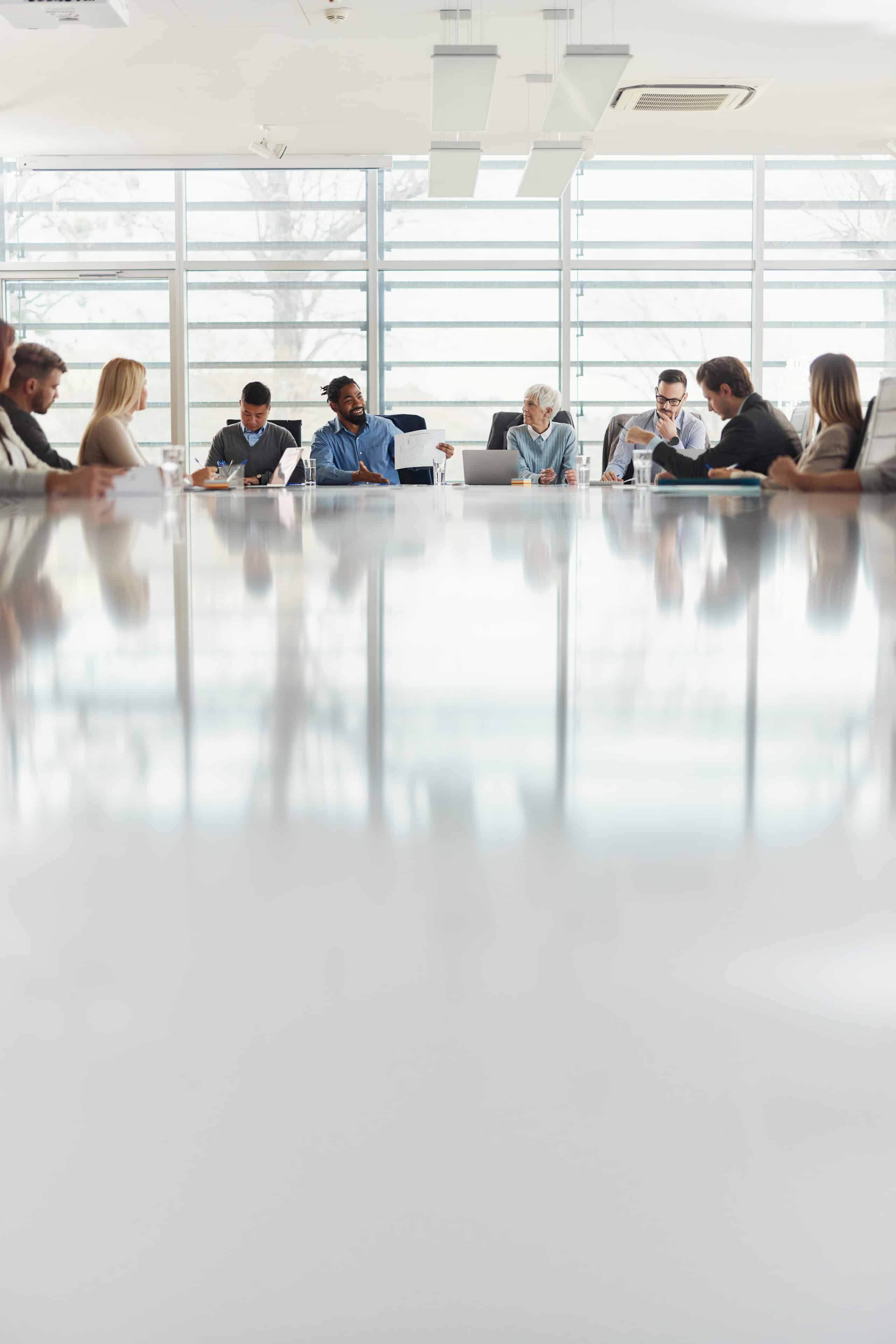 People in a modern conference room discuss commercial real estate facilities management consulting.