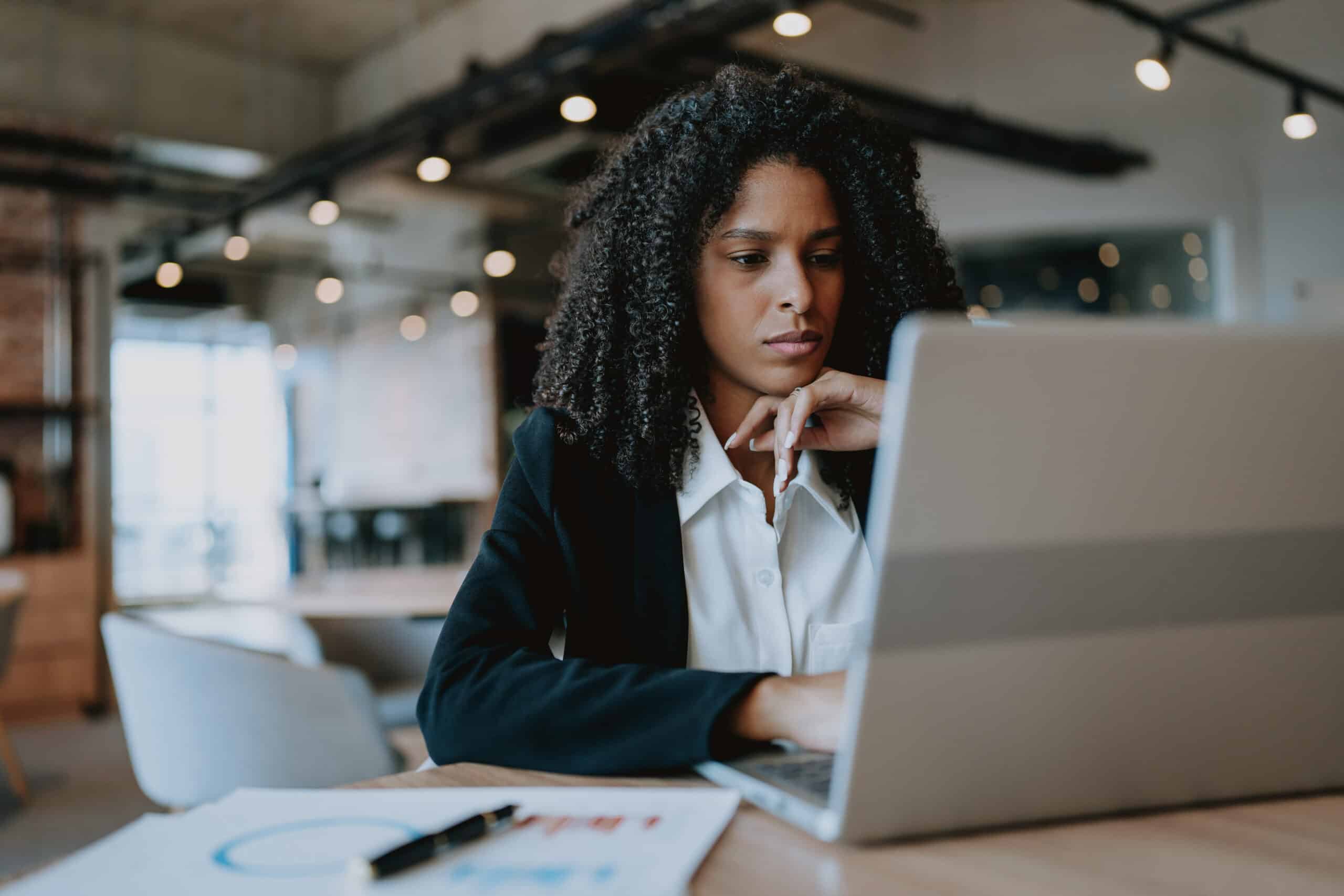 Woman in business attire working on a laptop, consulting on commercial real estate operations.