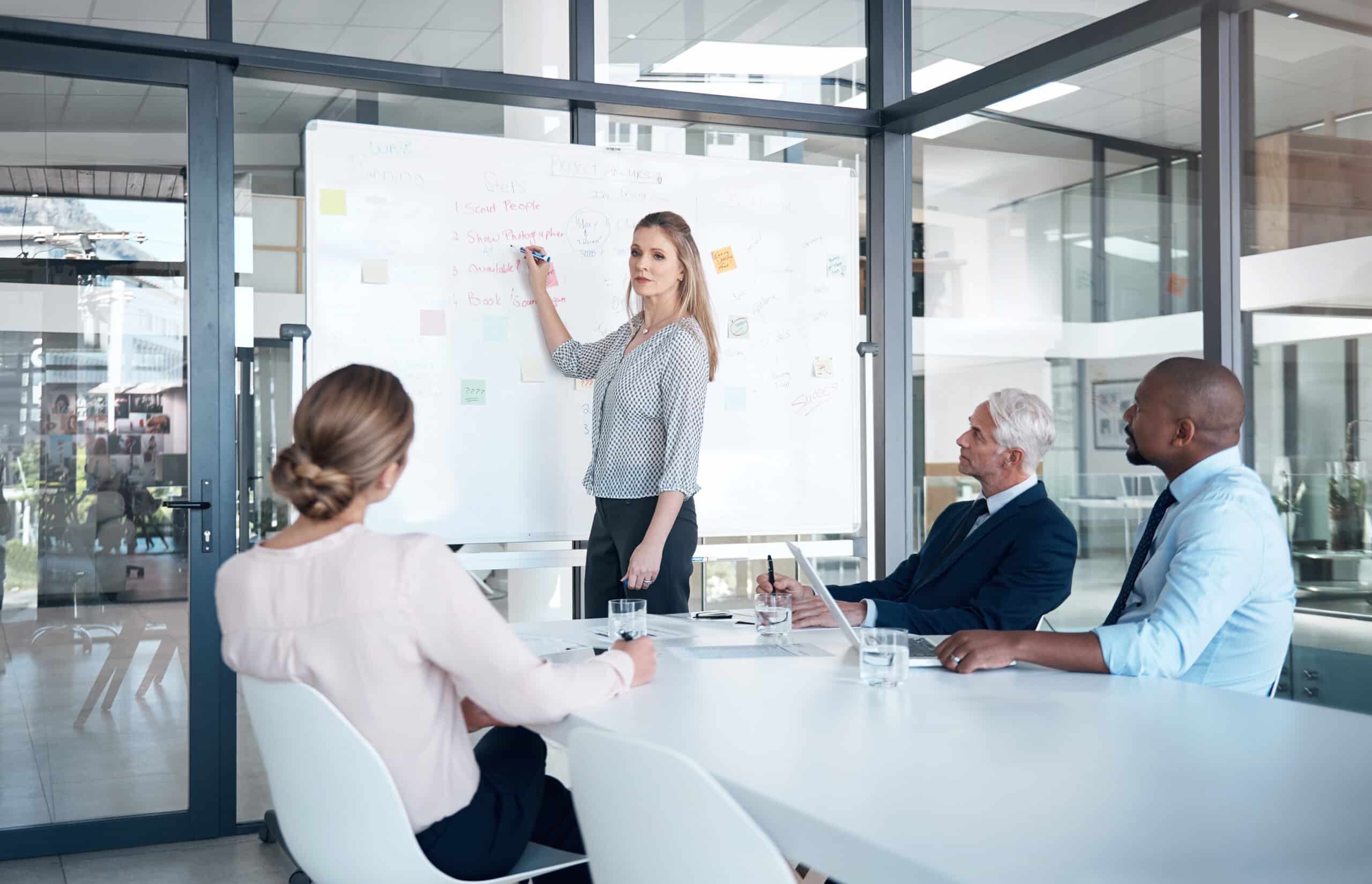 A woman presents commercial real estate tax management insights to colleagues in a modern office.