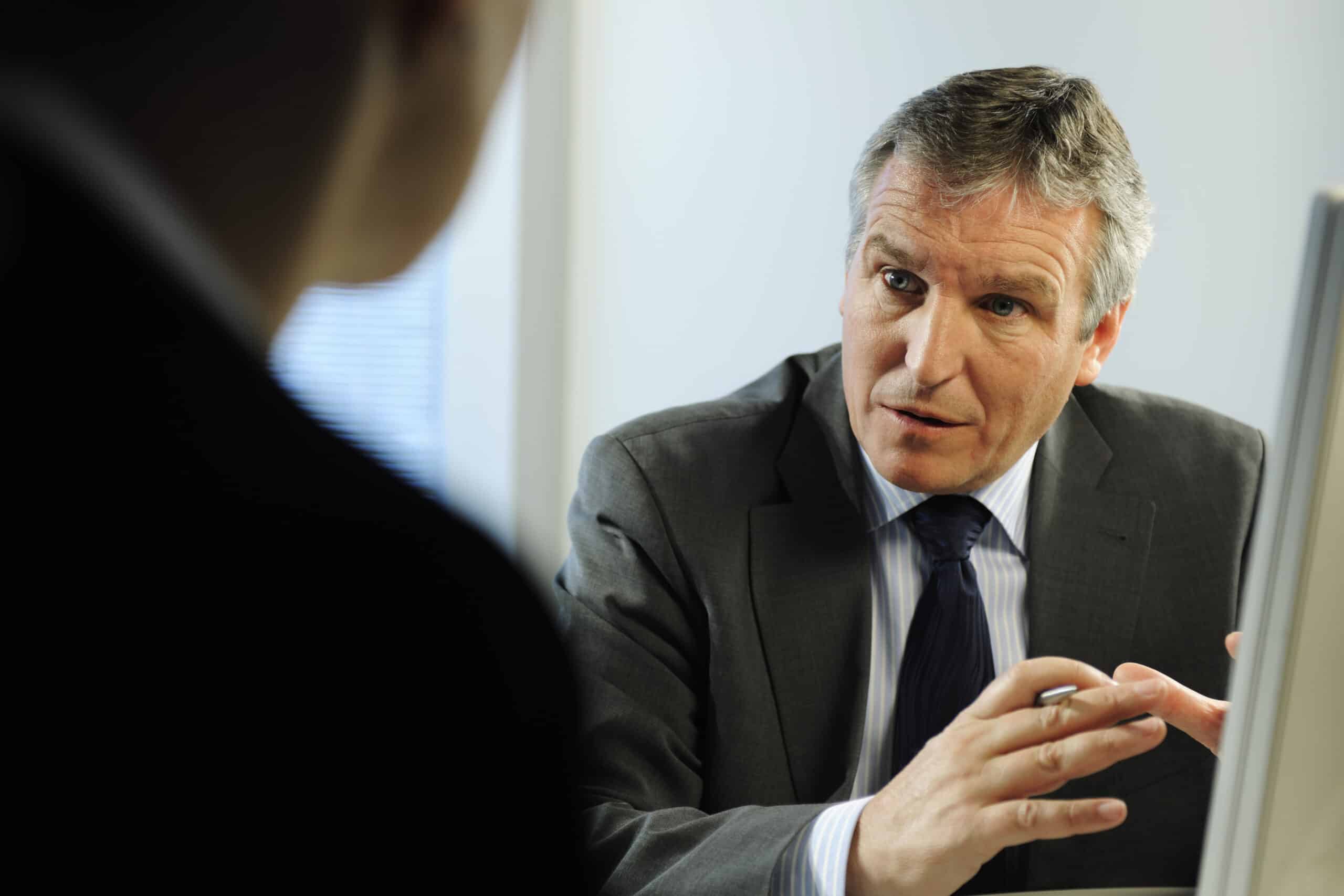 Man in suit discussing commercial lease dispute resolution in an office setting.