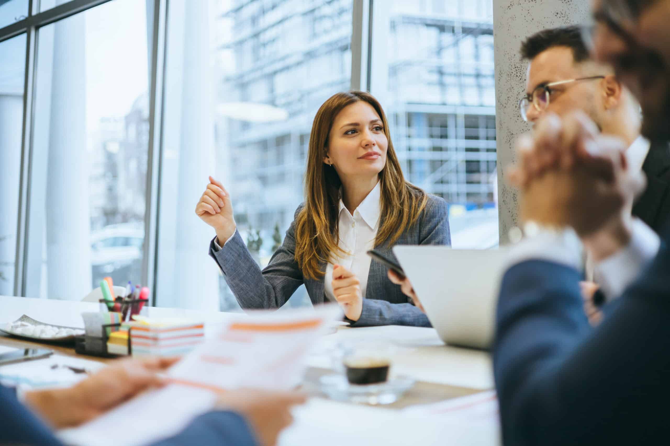 Businesswoman meeting with colleagues, discussing documents on commercial lease dispute resolution.