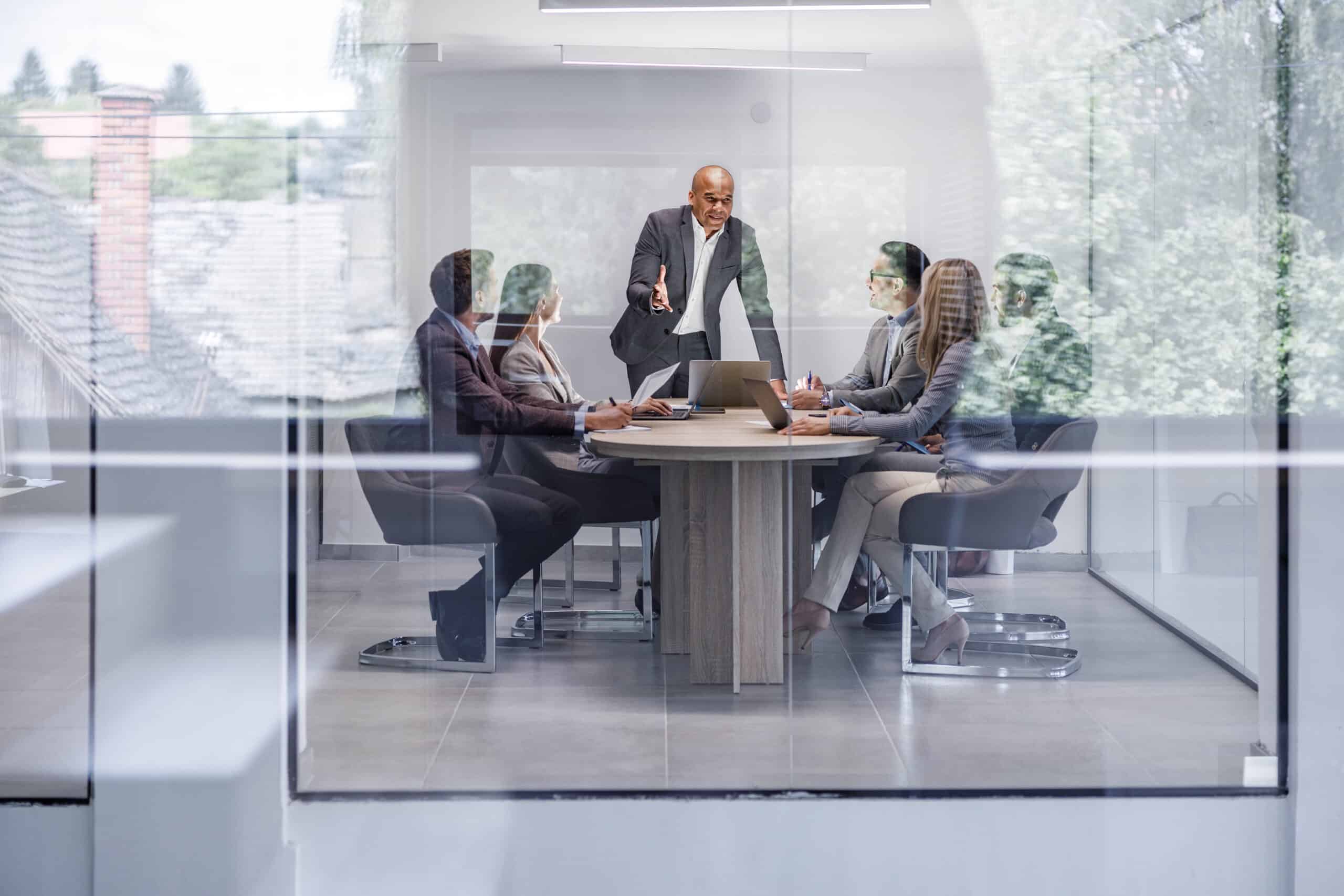 Business meeting with six people as enterprise application integration consultants discuss solutions.