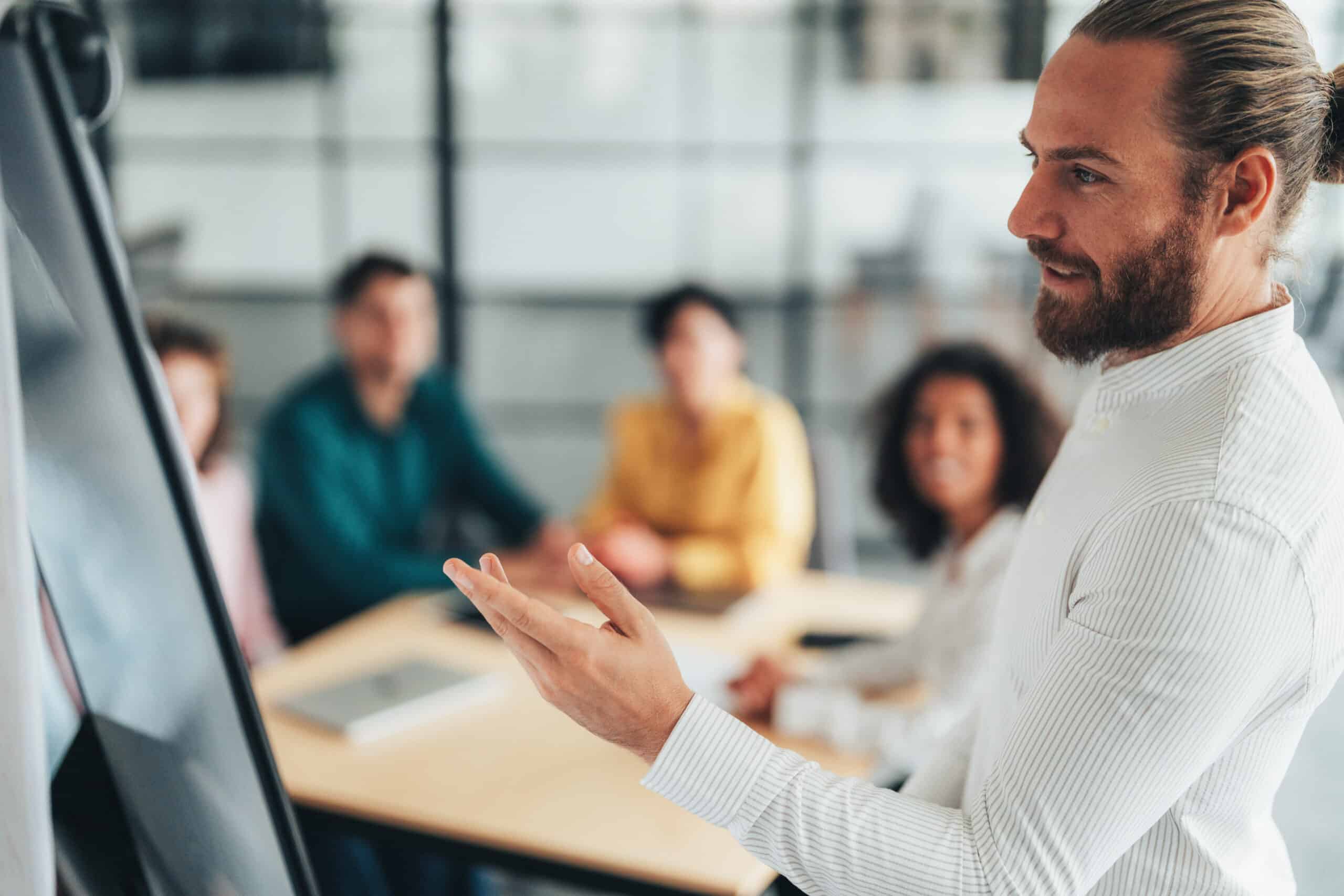 Man presenting expert witness services at a flip chart in a modern office meeting room.