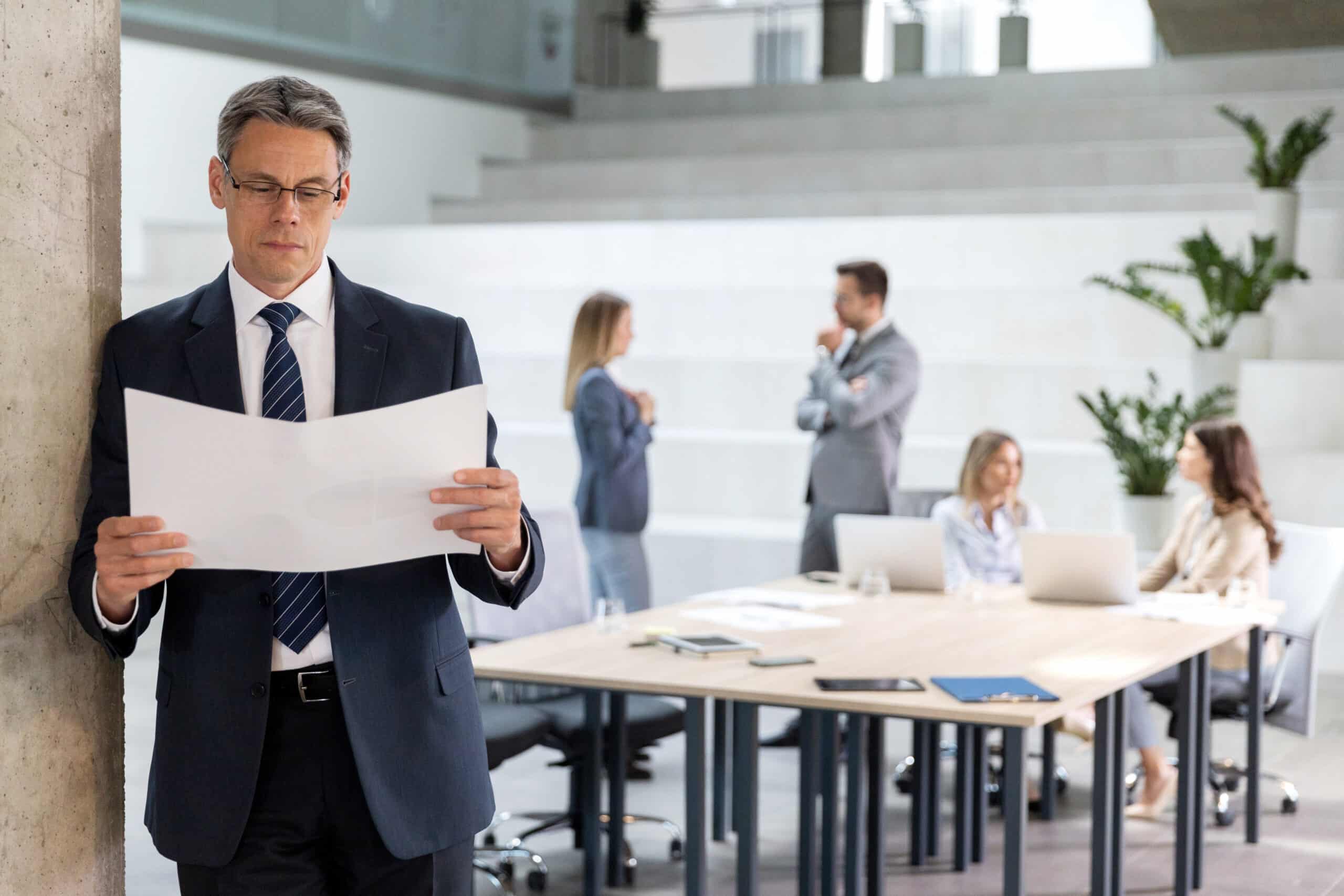 Man in suit reviewing papers; expert witness services consultants active in modern office.