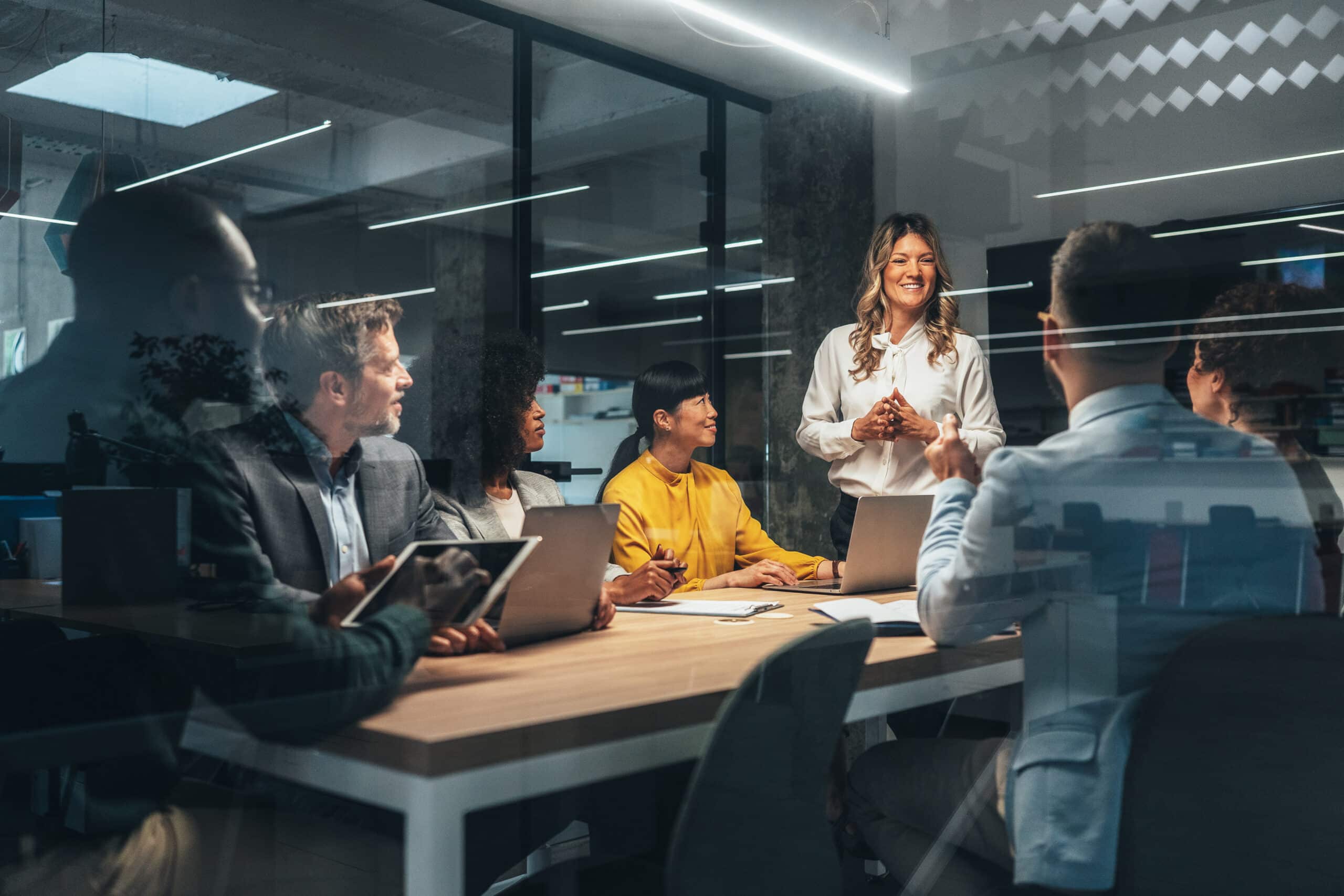 A woman presents intelligent automation consulting ideas to colleagues in a modern office.