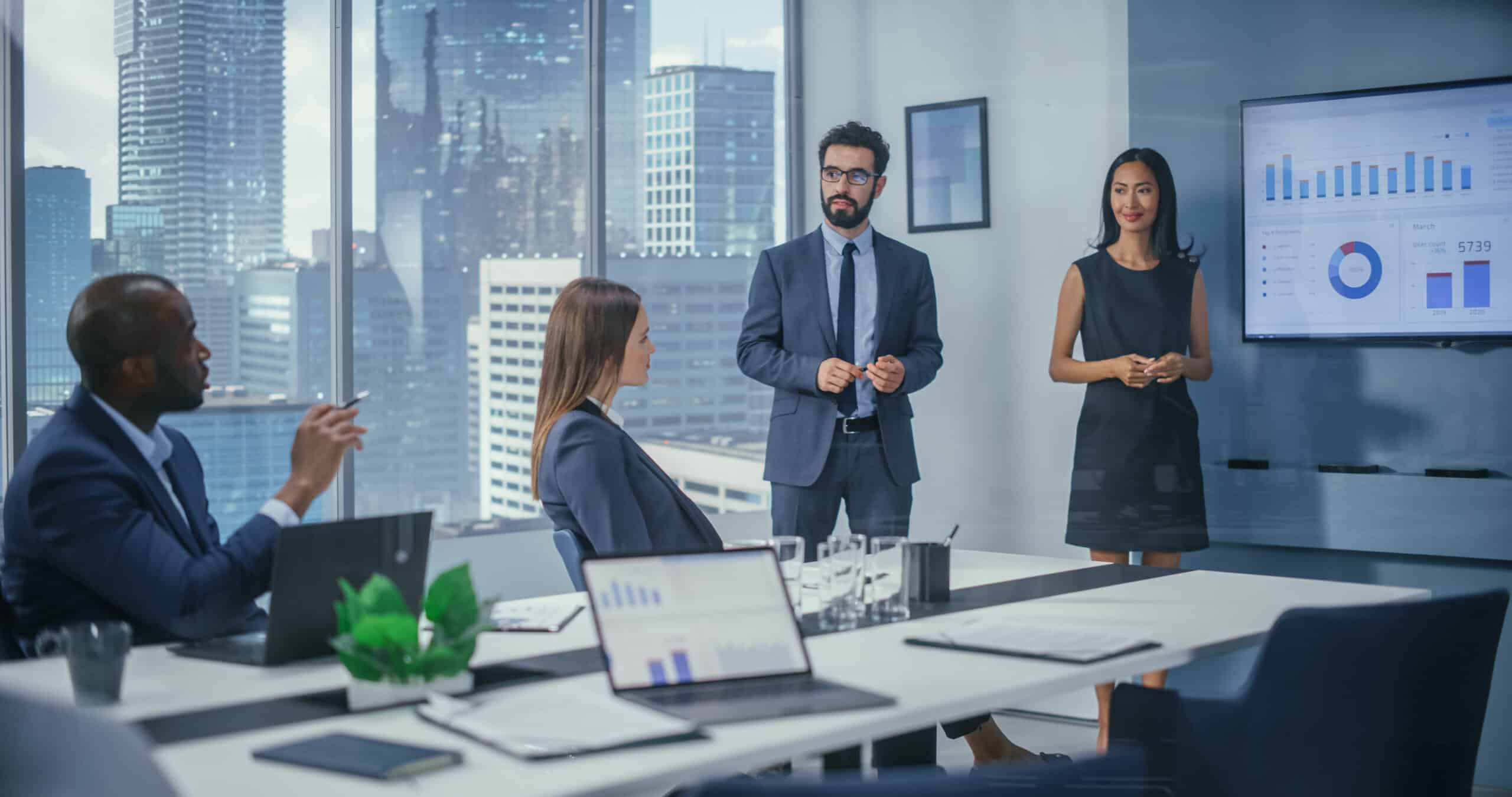 Four professionals in a meeting room discuss charts with location intelligence consultants.