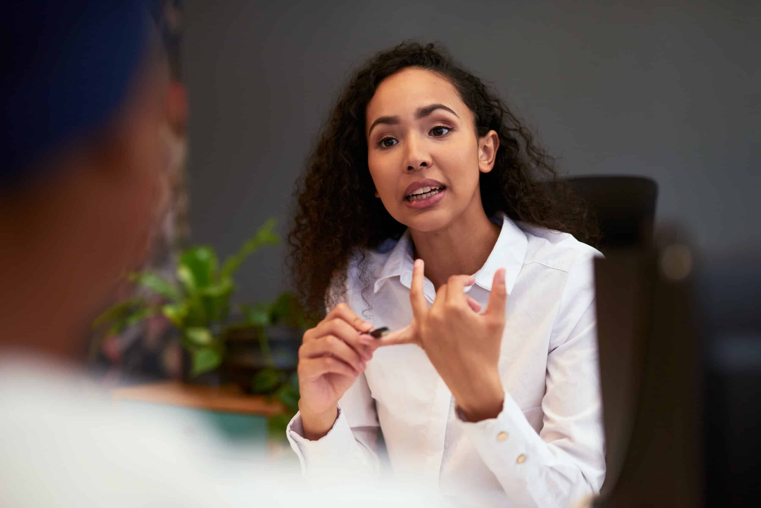 Woman in a white shirt discussing smart building consulting in an office setting.