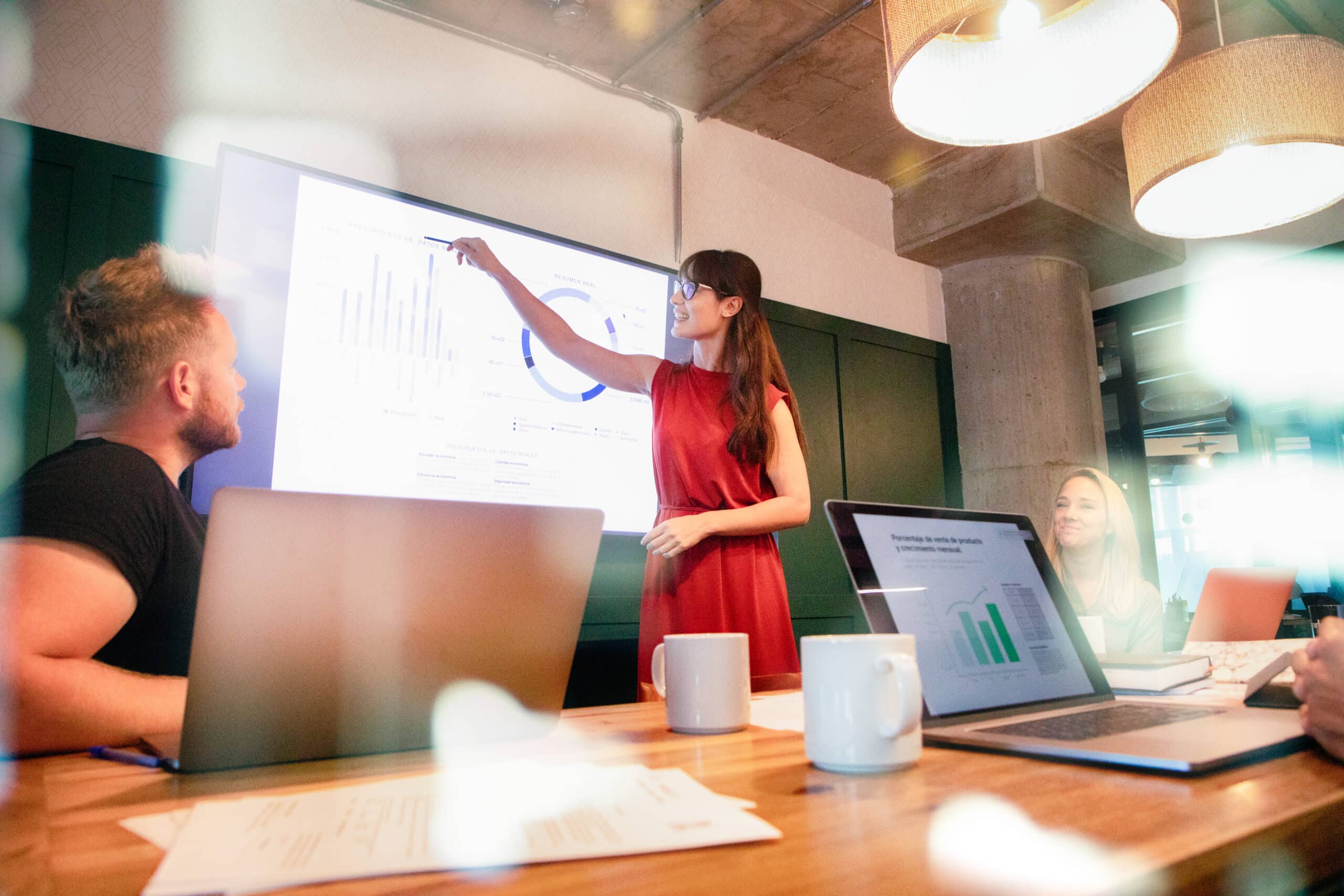 Woman presenting data on a screen to colleagues during an Enterprise Systems Transformation meeting.