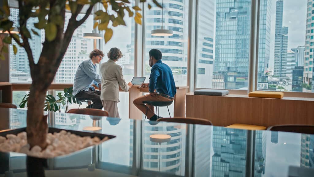 Three people collaborating for commercial real estate expansion strategy consulting