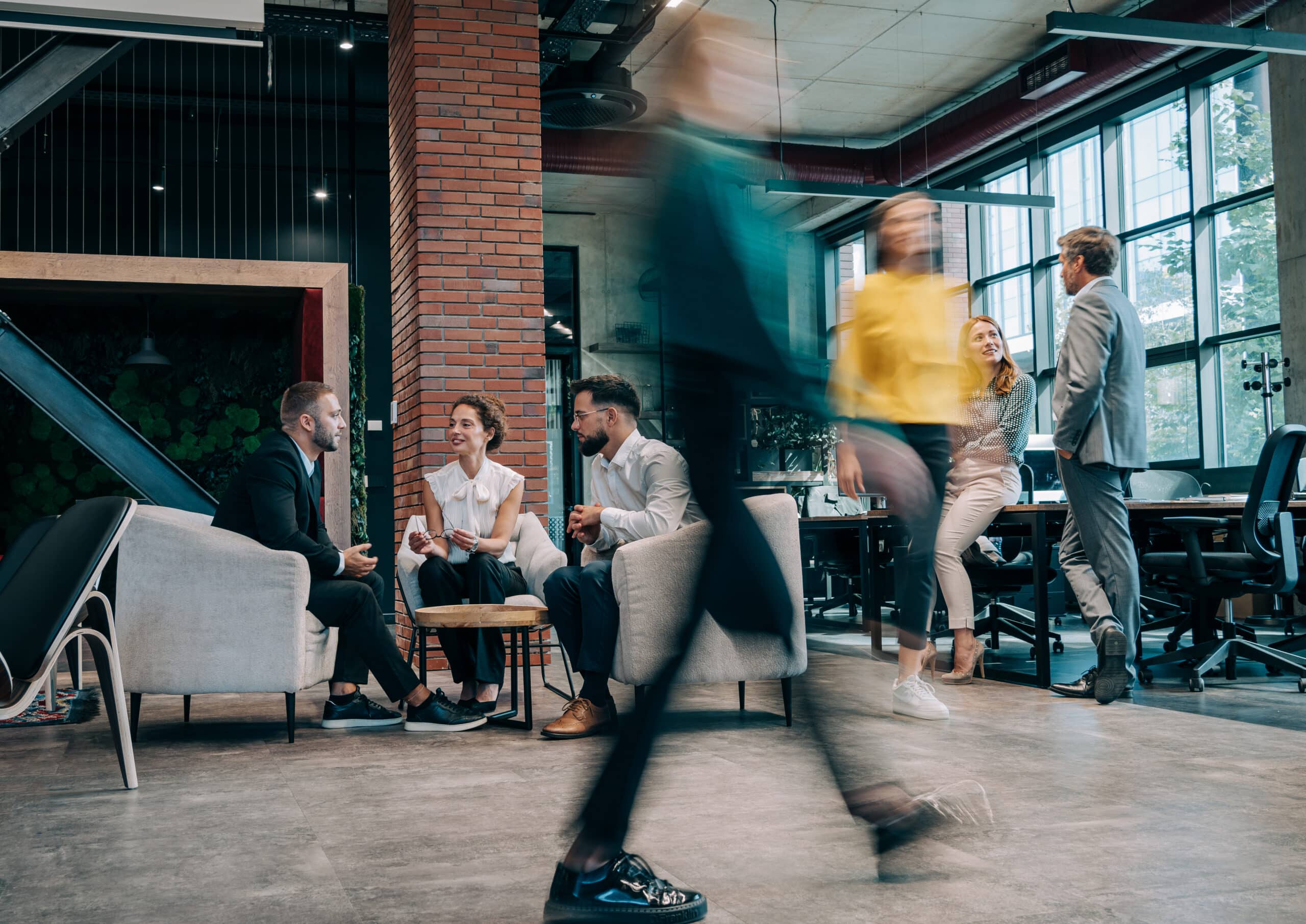 Modern office with Demand Forecasting Consultants engaging in conversation and collaborative work.