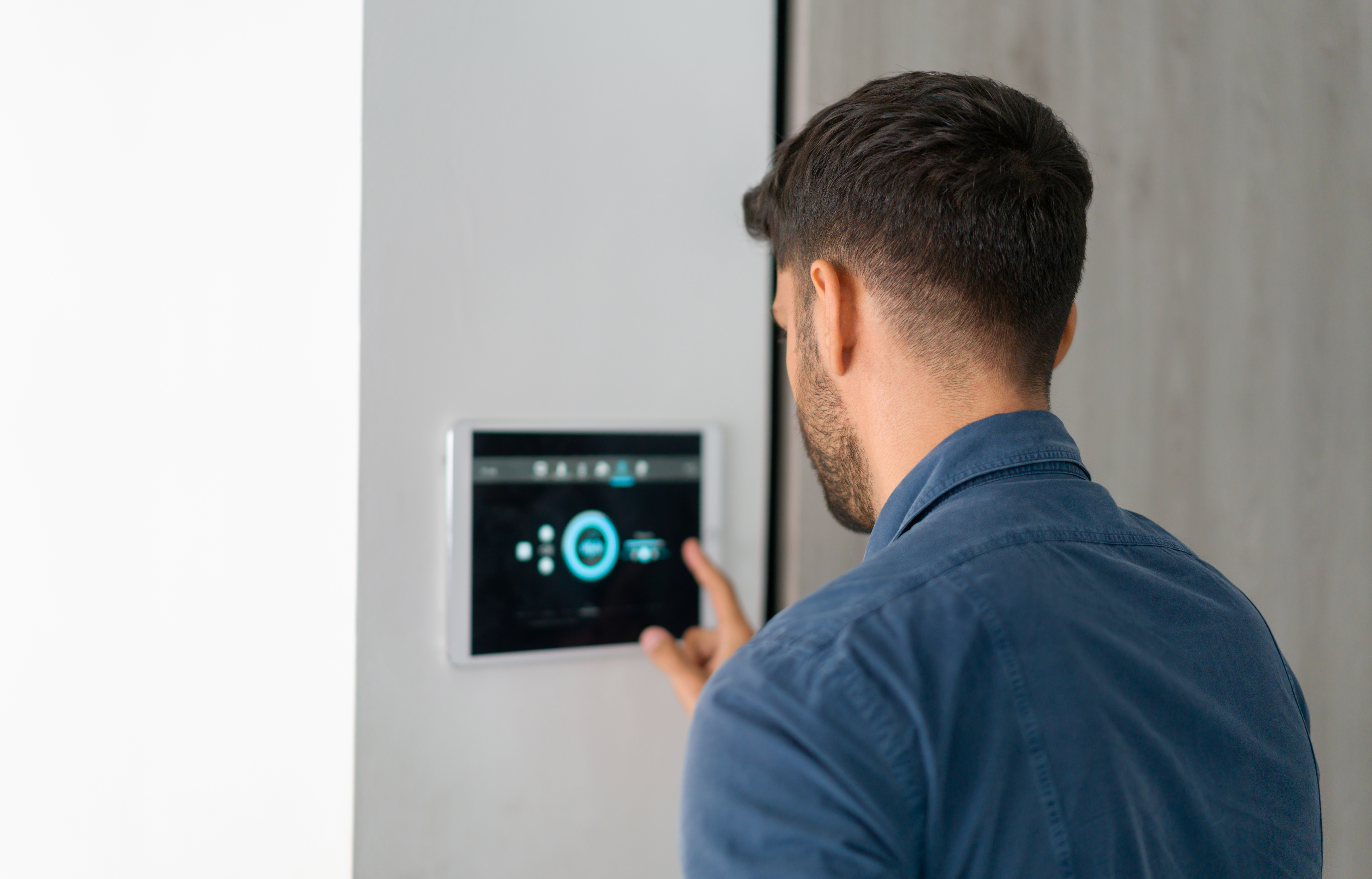 Man using smart home control panel symbolizing digital experience platform consulting