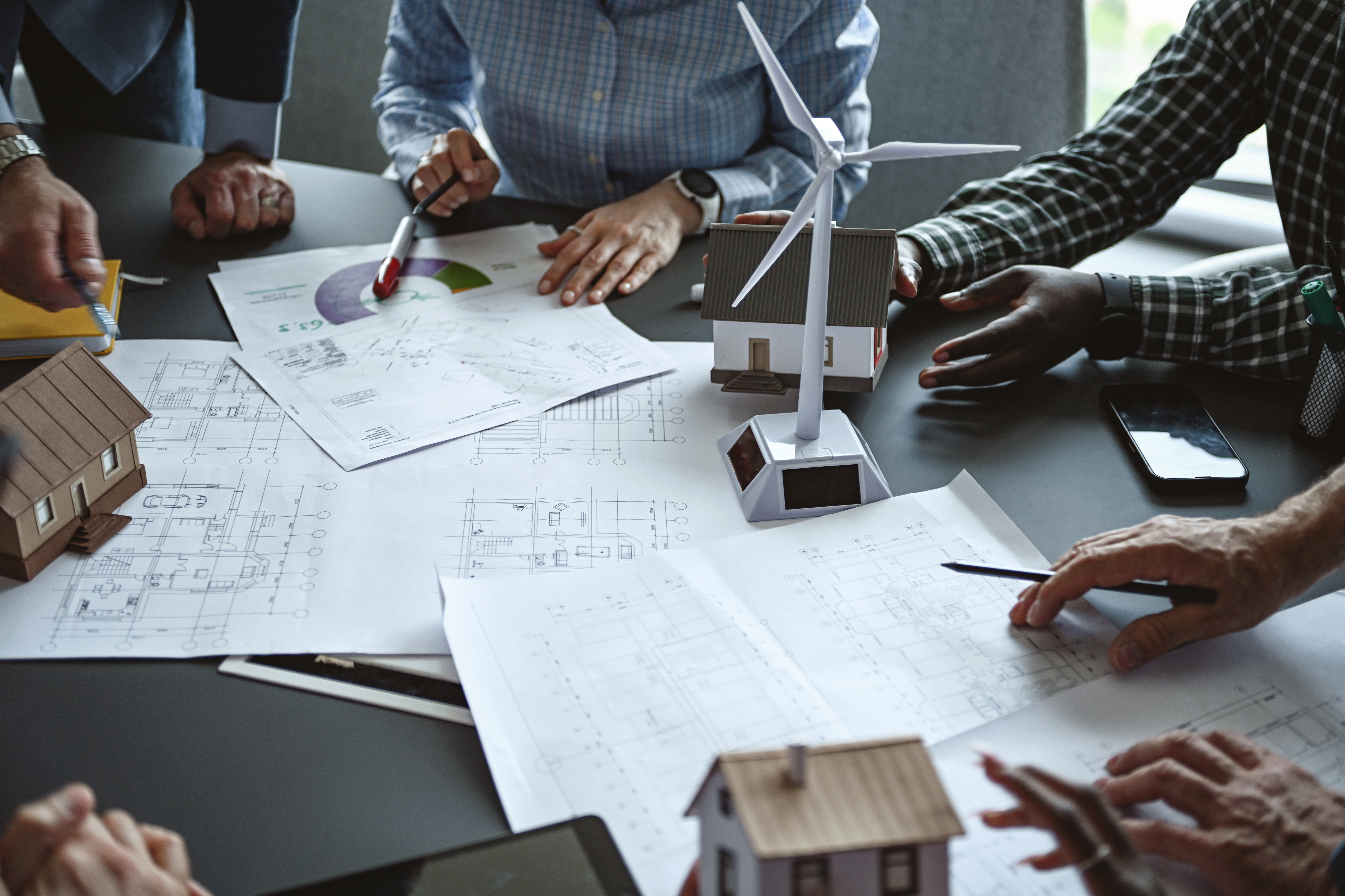 team of professionals discusses the construction of suburban housing and equipping it with alternative energy