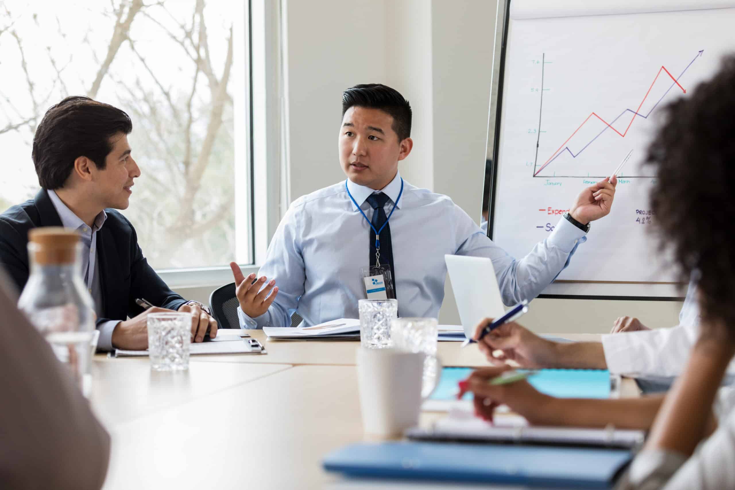 A man pointing at a whiteboard during a CRE workplace strategy discussion.