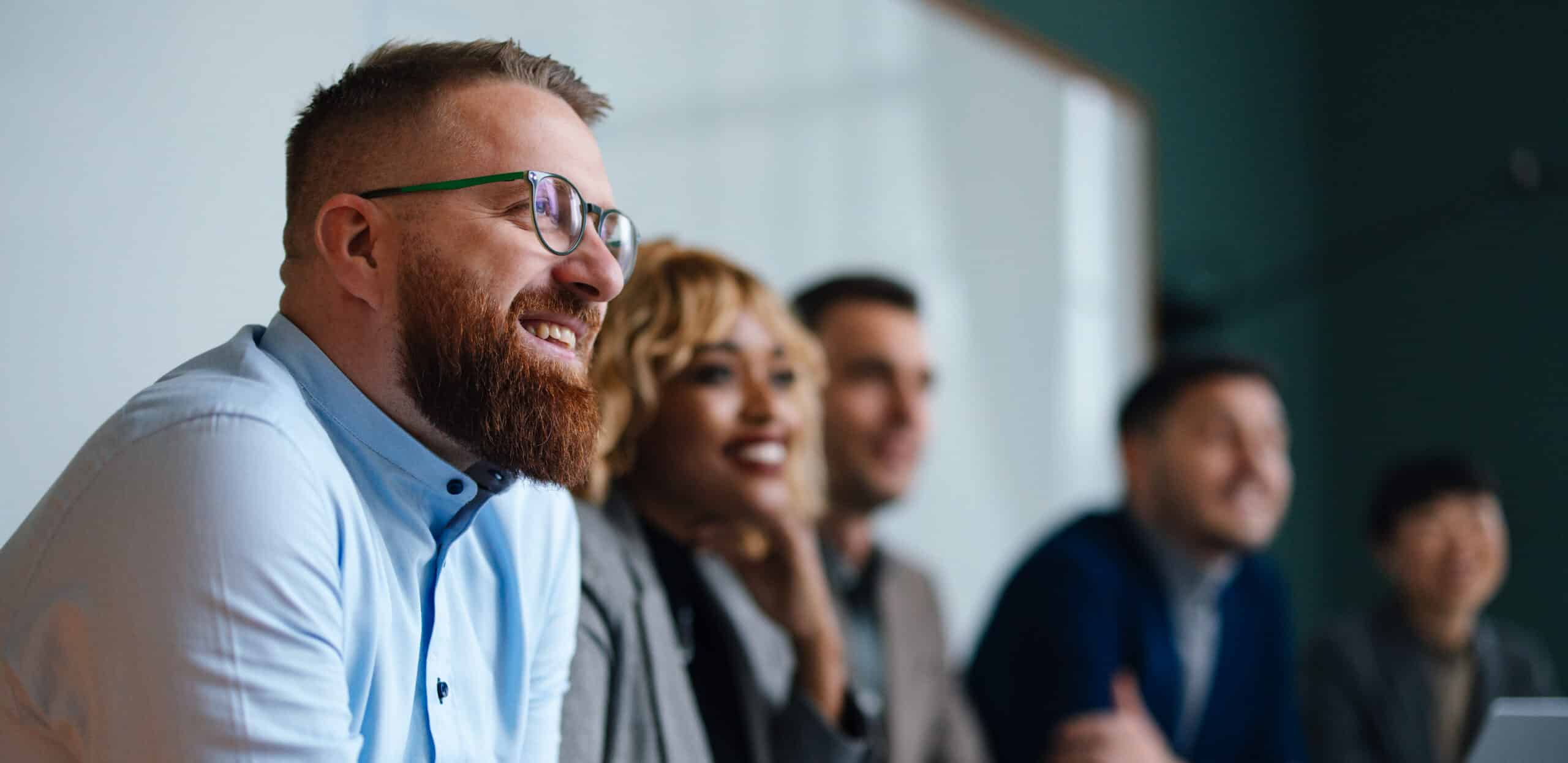 A group of people sitting in a row at an AI Governance Consulting meeting.