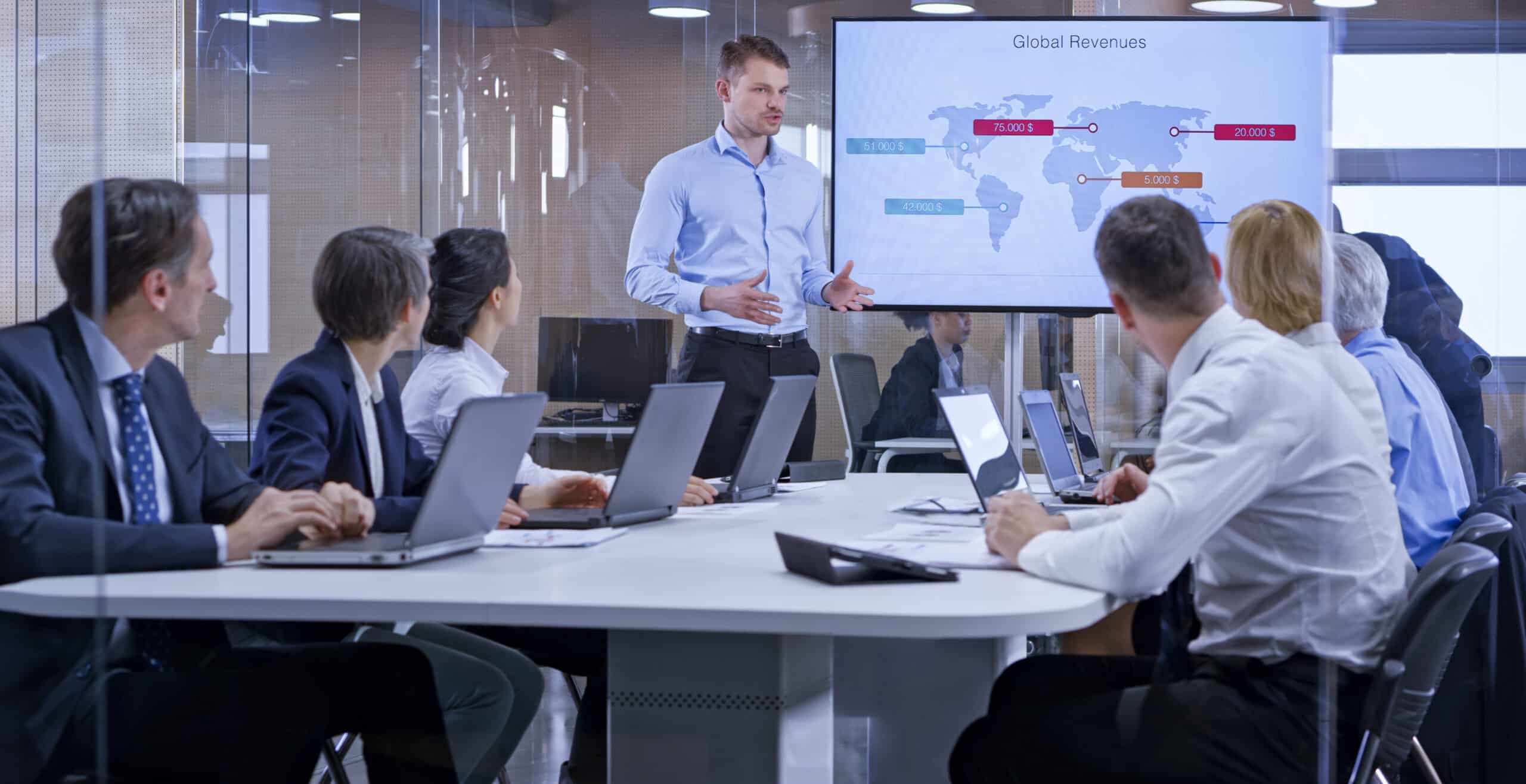 Businessman holding a presentation using display in glass conference room