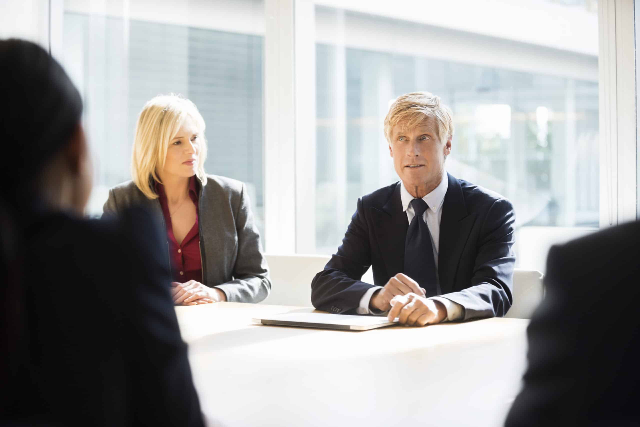 Two professionals meet in a bright office for Geospatial Analytics Consulting discussions.
