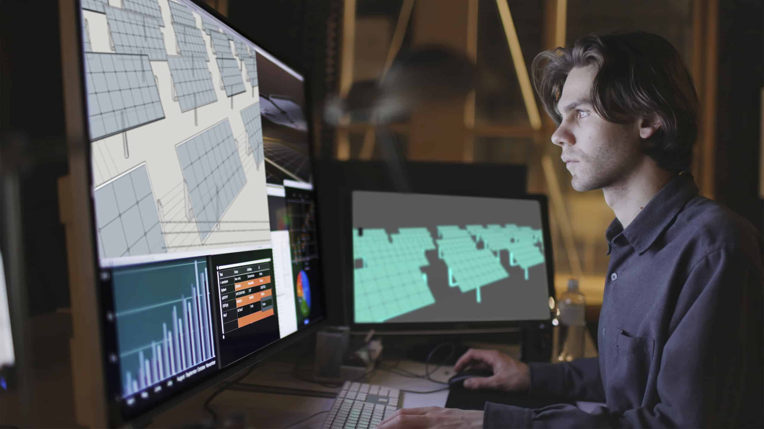 Man working on 3D modeling and data analysis at a computer workstation with multiple screens.