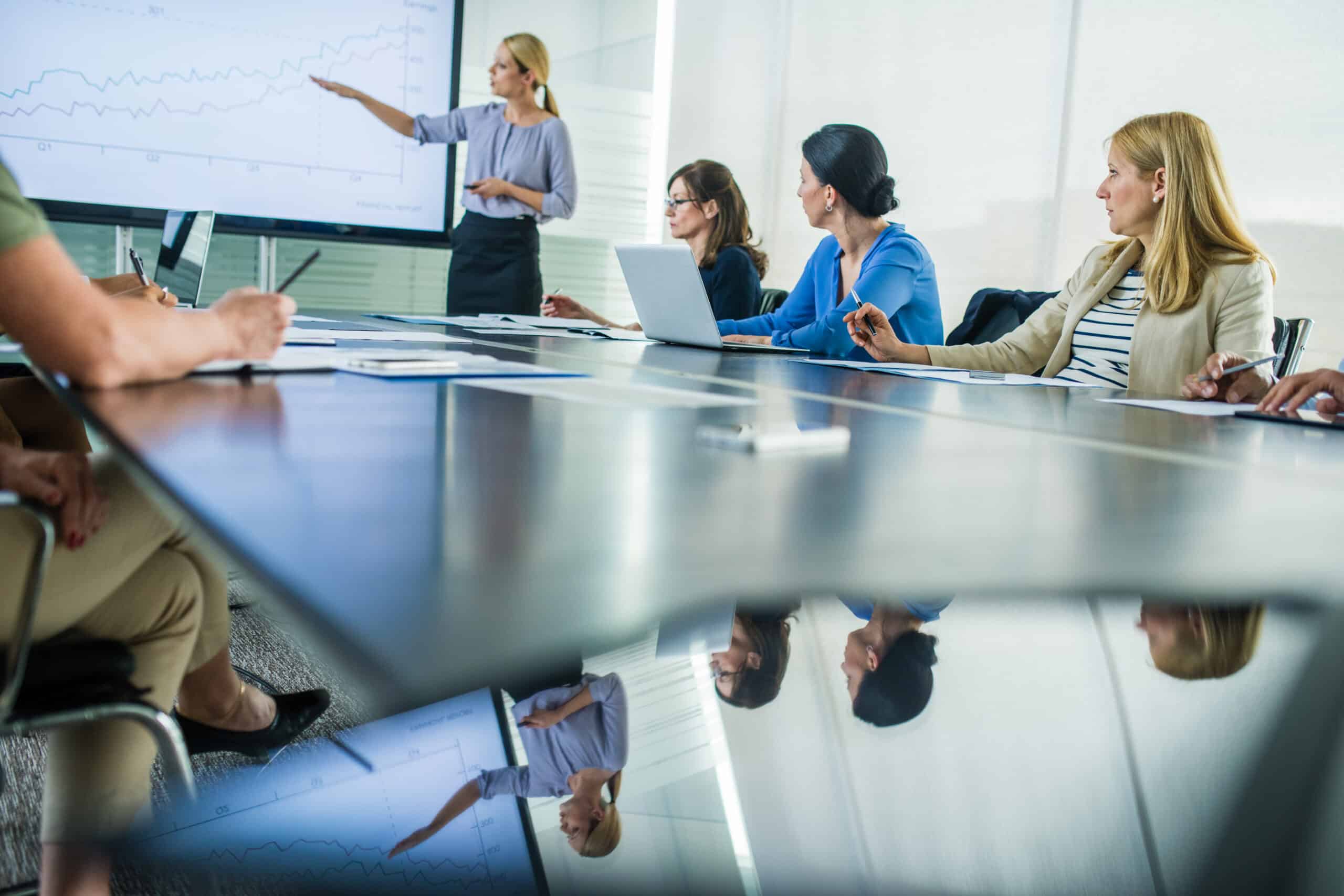 Businesswoman giving presentation in conference room.
