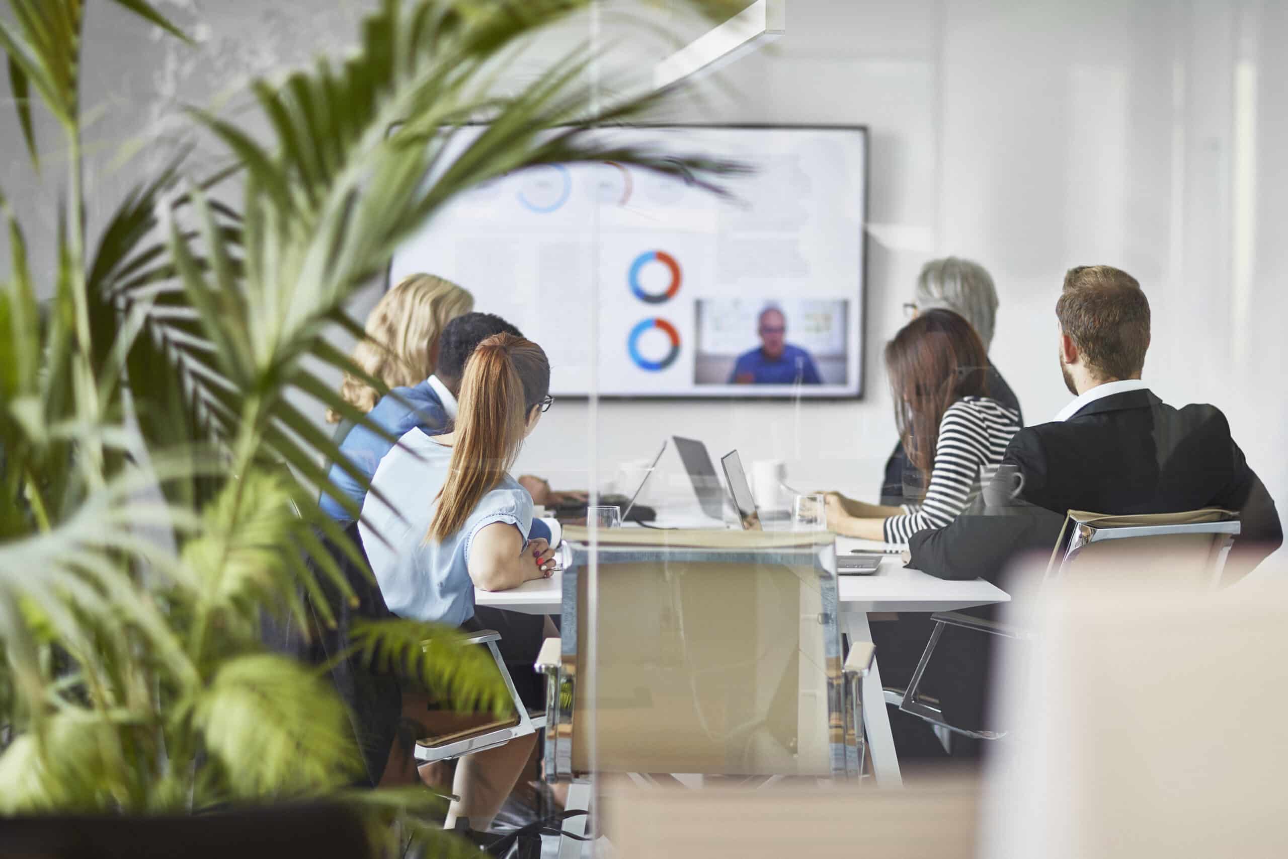 People in a conference room watch a presentation on Smart Building consulting solutions.