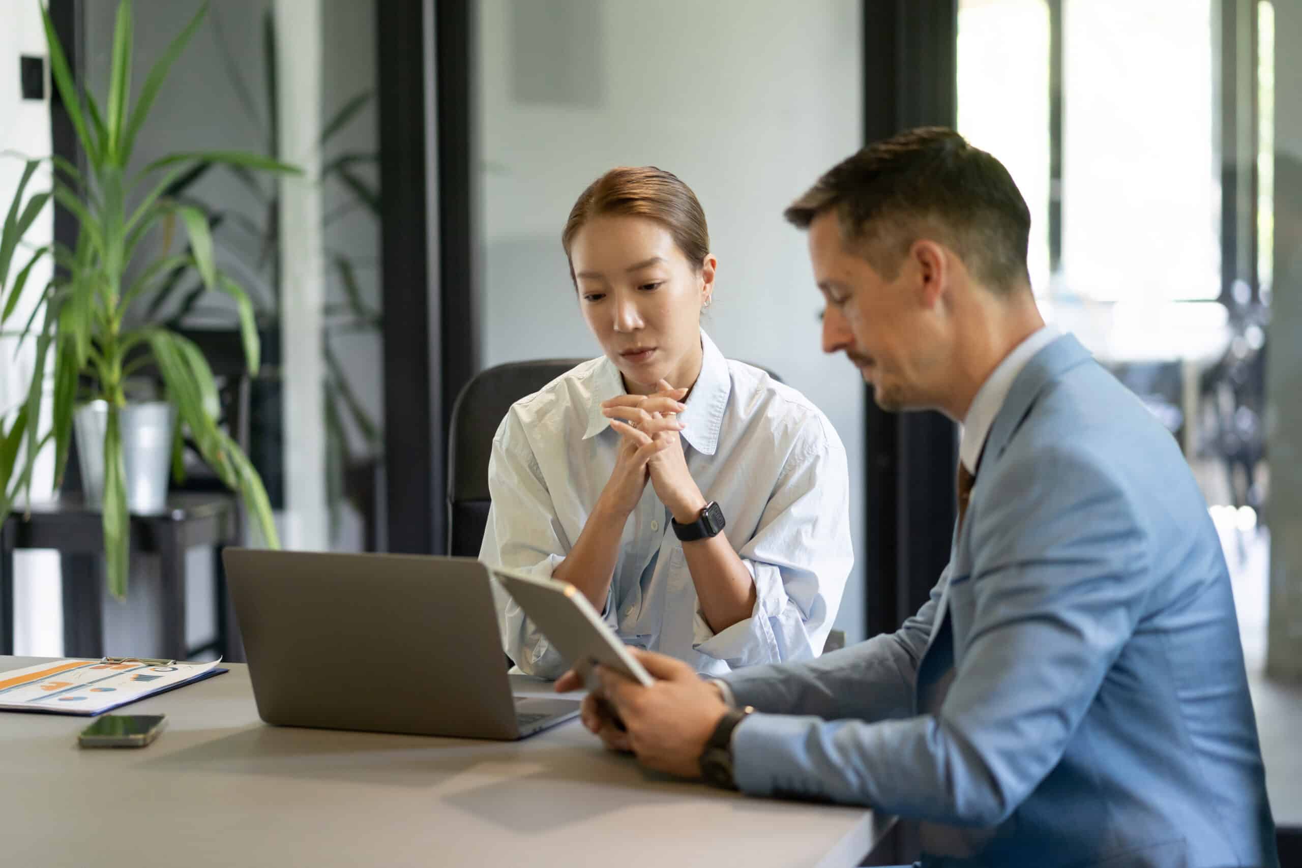Business colleagues collaborating on a project using digital tablet and laptop in office