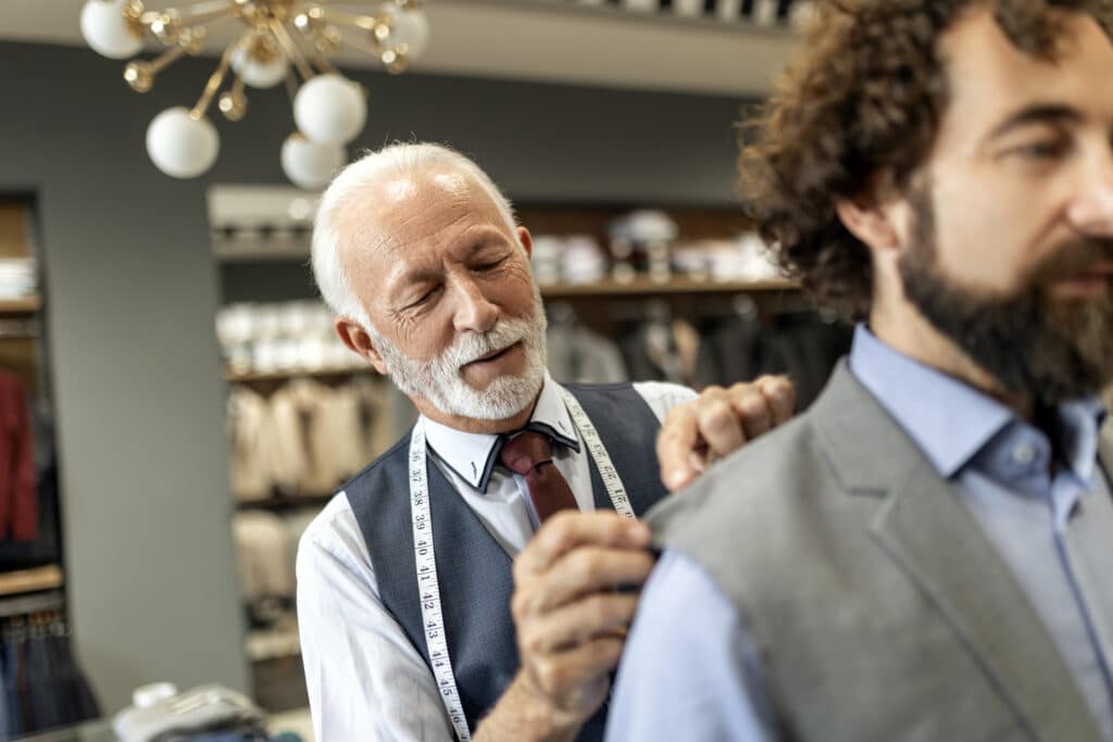 Experienced Tailor Working with Customer on Bespoke Suit Fitting