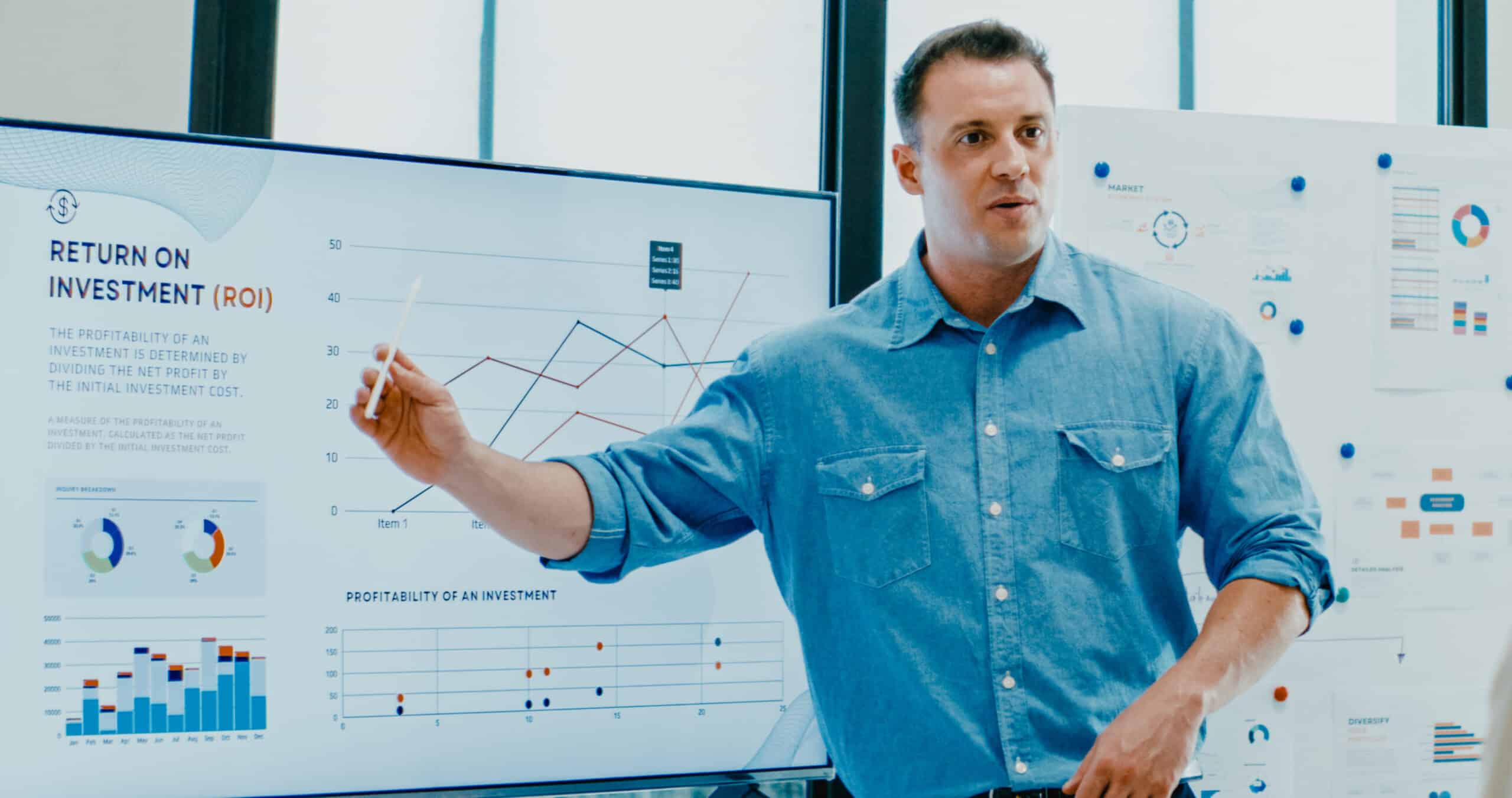 Man presenting ROI data and charts on 5G monetization consulting in a modern office setting.