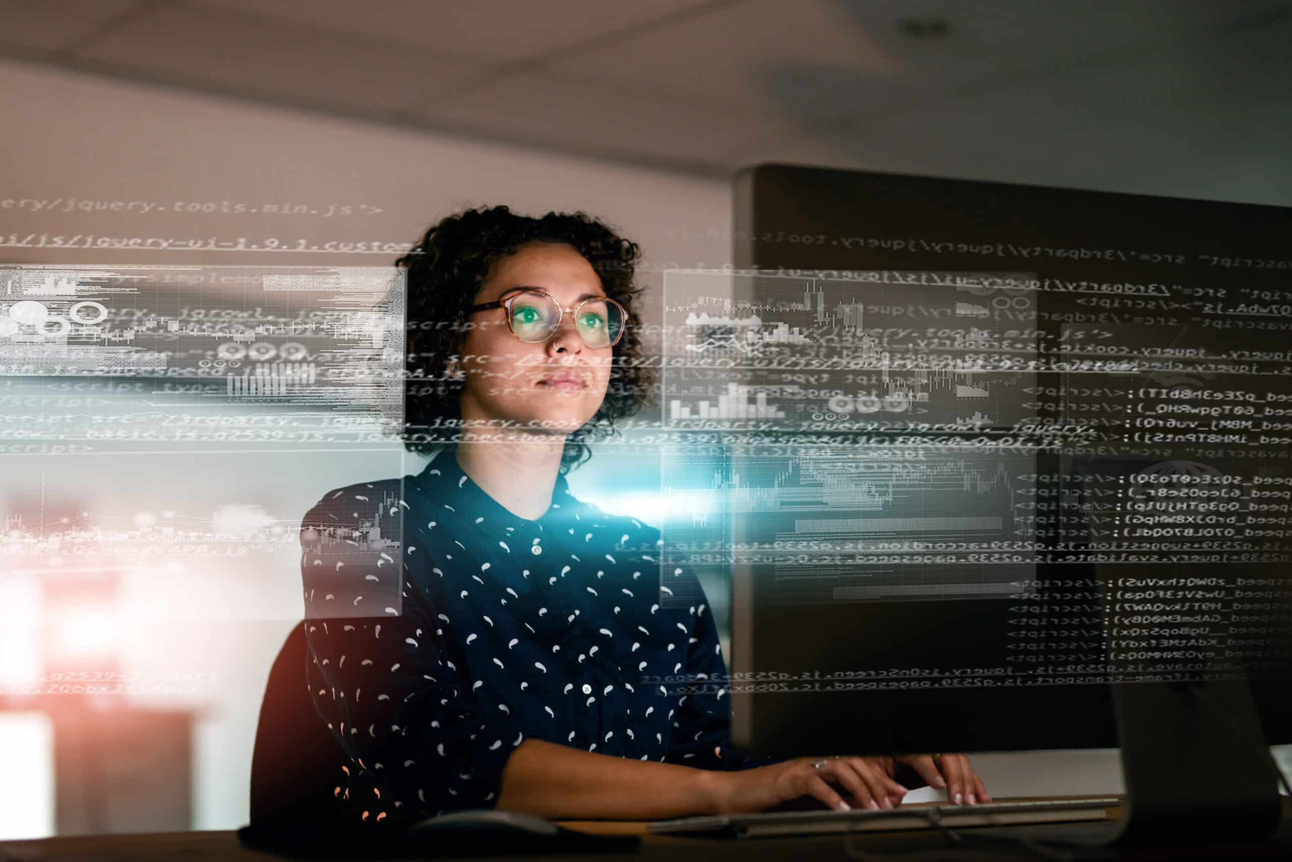 Woman at computer with code and data, immersed in ai transformation consulting solutions.