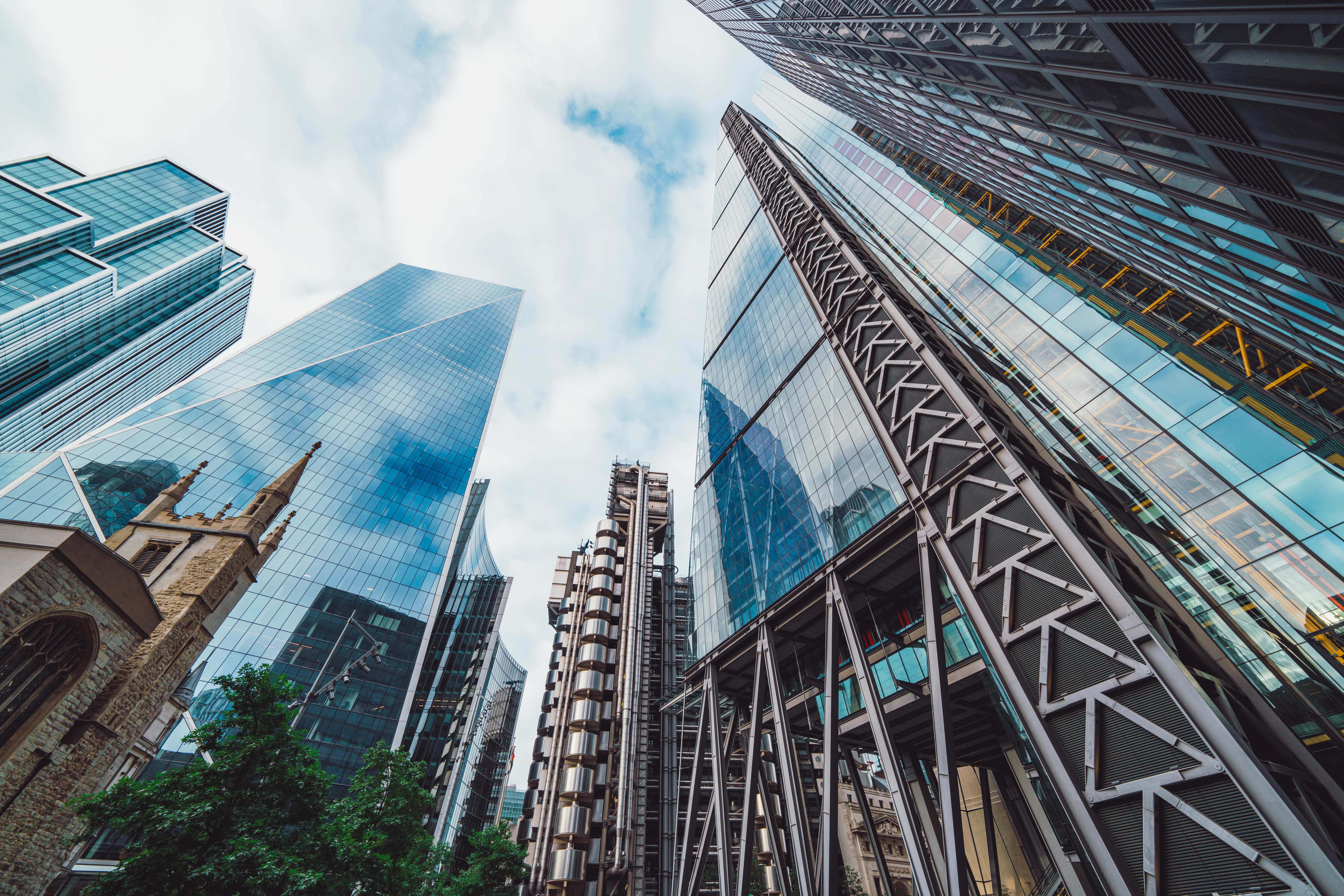 Tall modern glass skyscrapers, an old church tower—urban growth meets capital investment strategy.