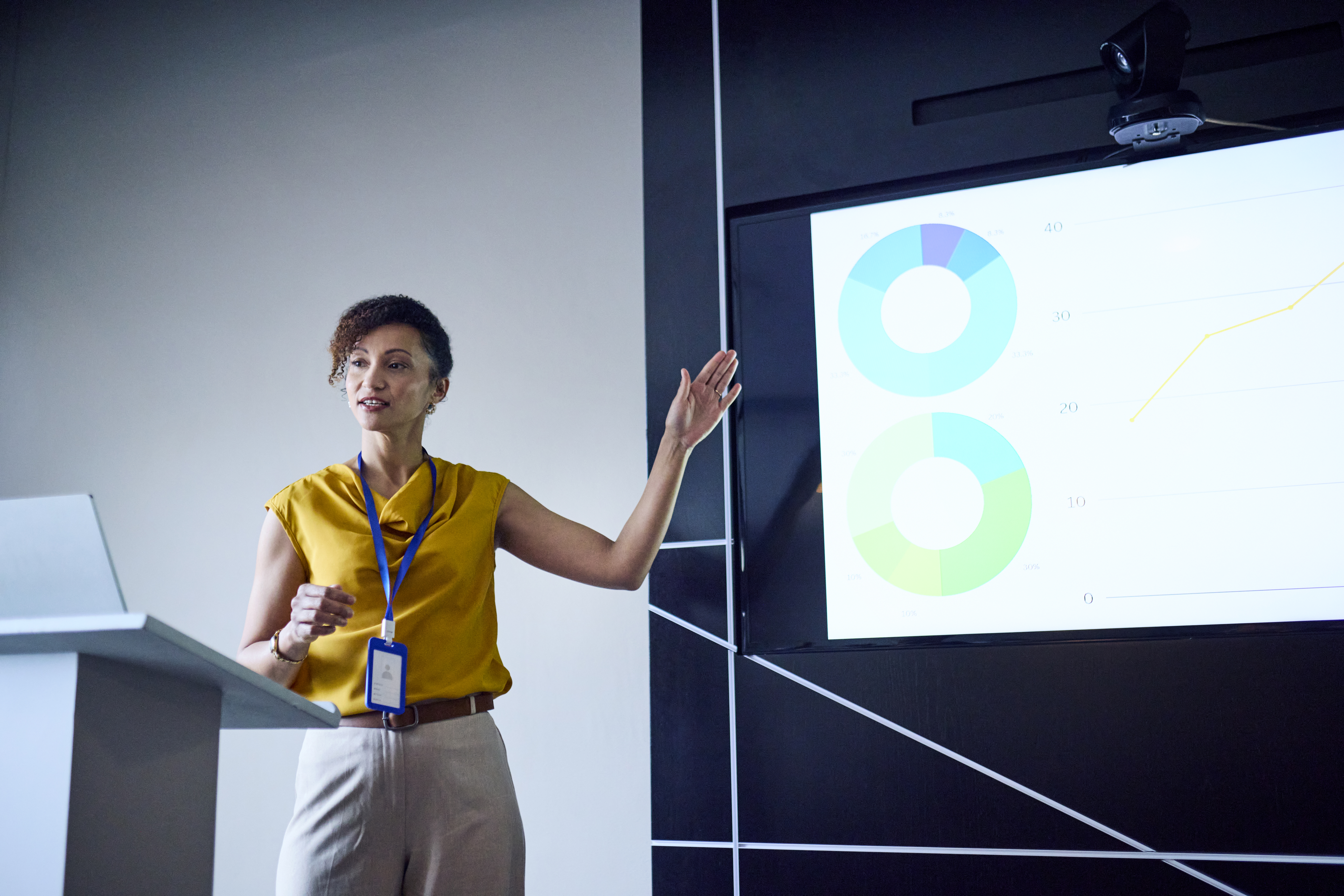 Professional woman presenting data on a screen representing cost reduction consulting