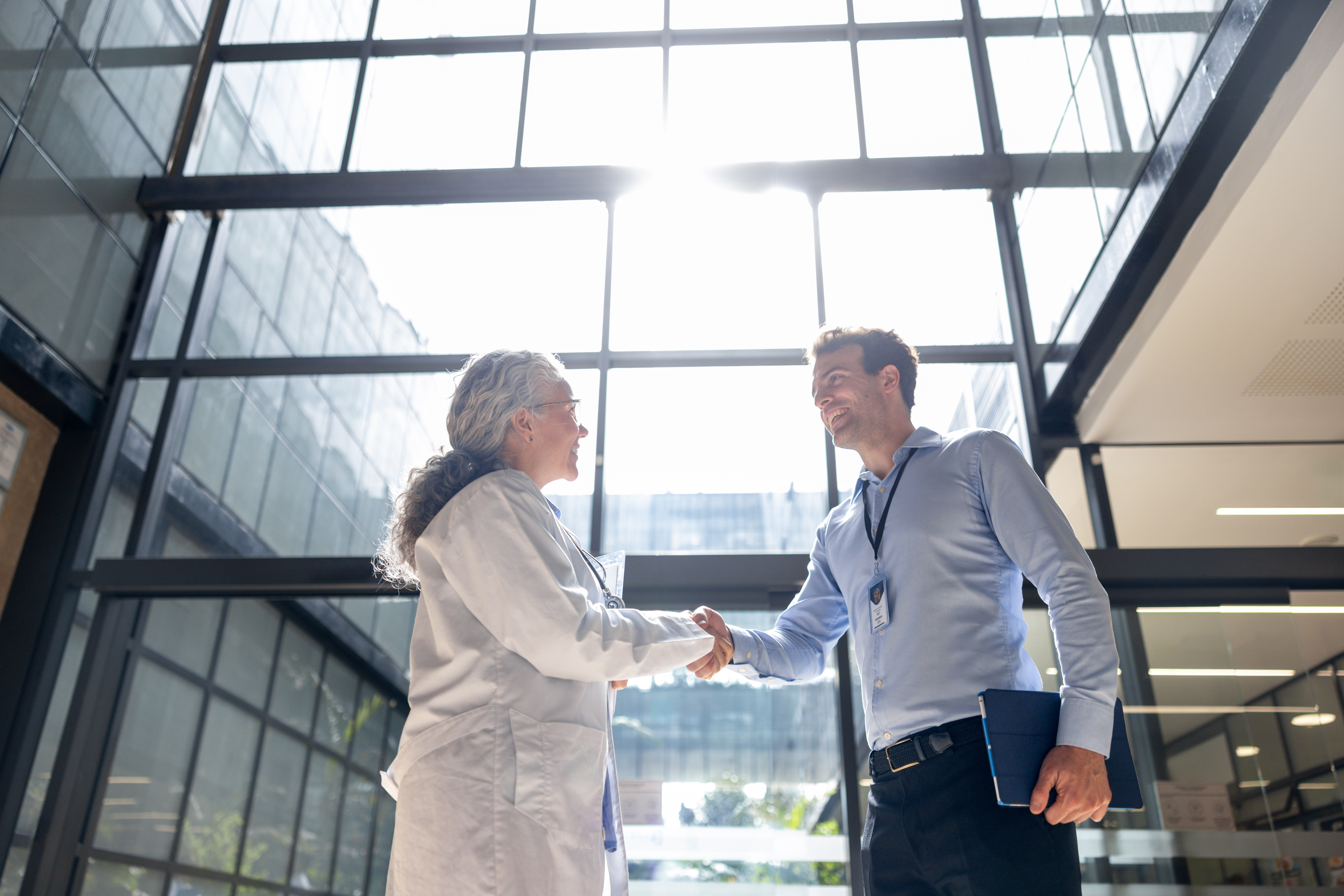 Sales representative greets potential client with a handshake representing telecom b2b growth strategy consulting